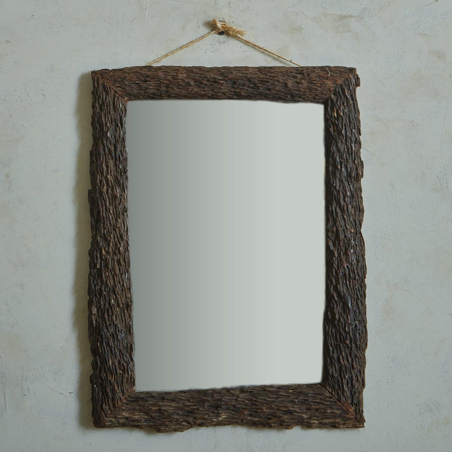 A vintage Bavarian wall mirror featuring a rectangular wood frame with hand carved etchings. The porous finish reminds us of tree bark + gives it a beautiful organic presence. This piece has a wooden backing and hardware for hanging. Unmarked. 20th