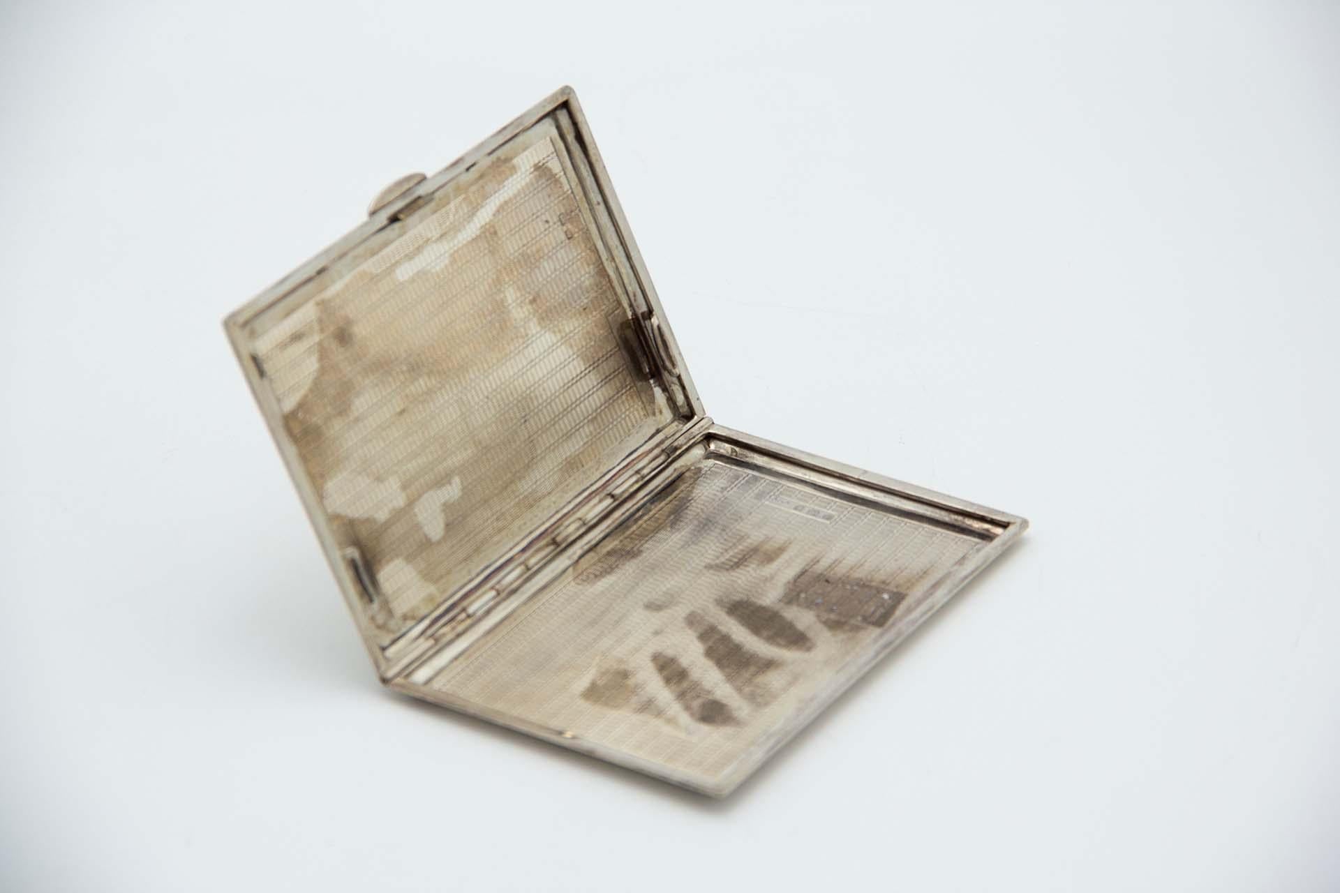 Description : Etui à cigarettes rectangulaire en argent guilloché avec bandes sur le dessus et intérieur avec carte monogramme. Métal : Argent. Origine : Anglais. Marque : Birmingham. Poids : 198,37 grammes. Dimensions : 12,7 cm x 1 cm : 12.7cmx1cm.