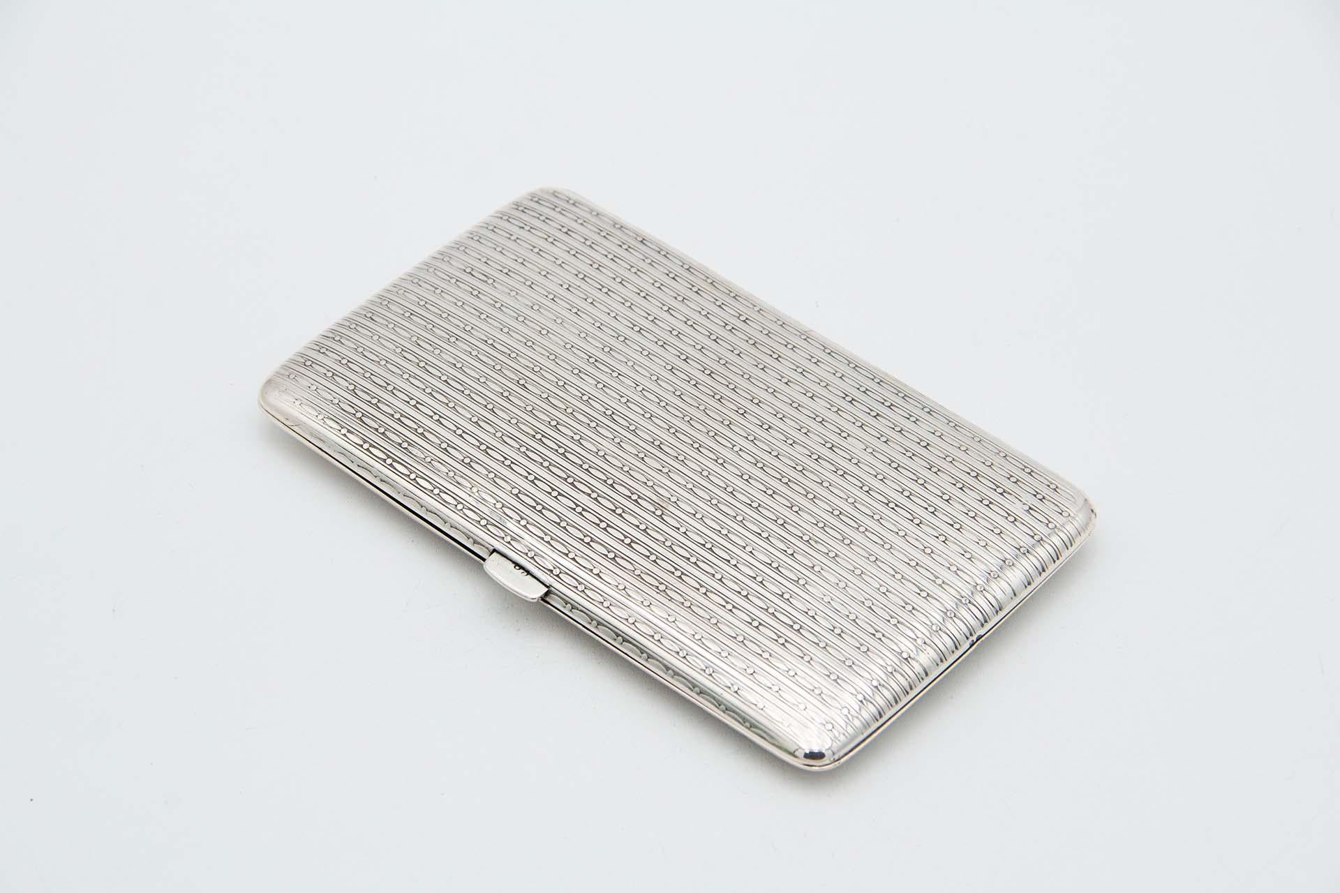 Description : Etui à cigarettes rectangulaire en argent guilloché de forme asymétrique avec couvercle à charnière. Métal : Argent. Origine : Portugais. Marque : javali II Titre. Poids : 159,57 grammes. Dimensions : 14,3 cm x 1,5 cm : 14.3cmx1.5cm.