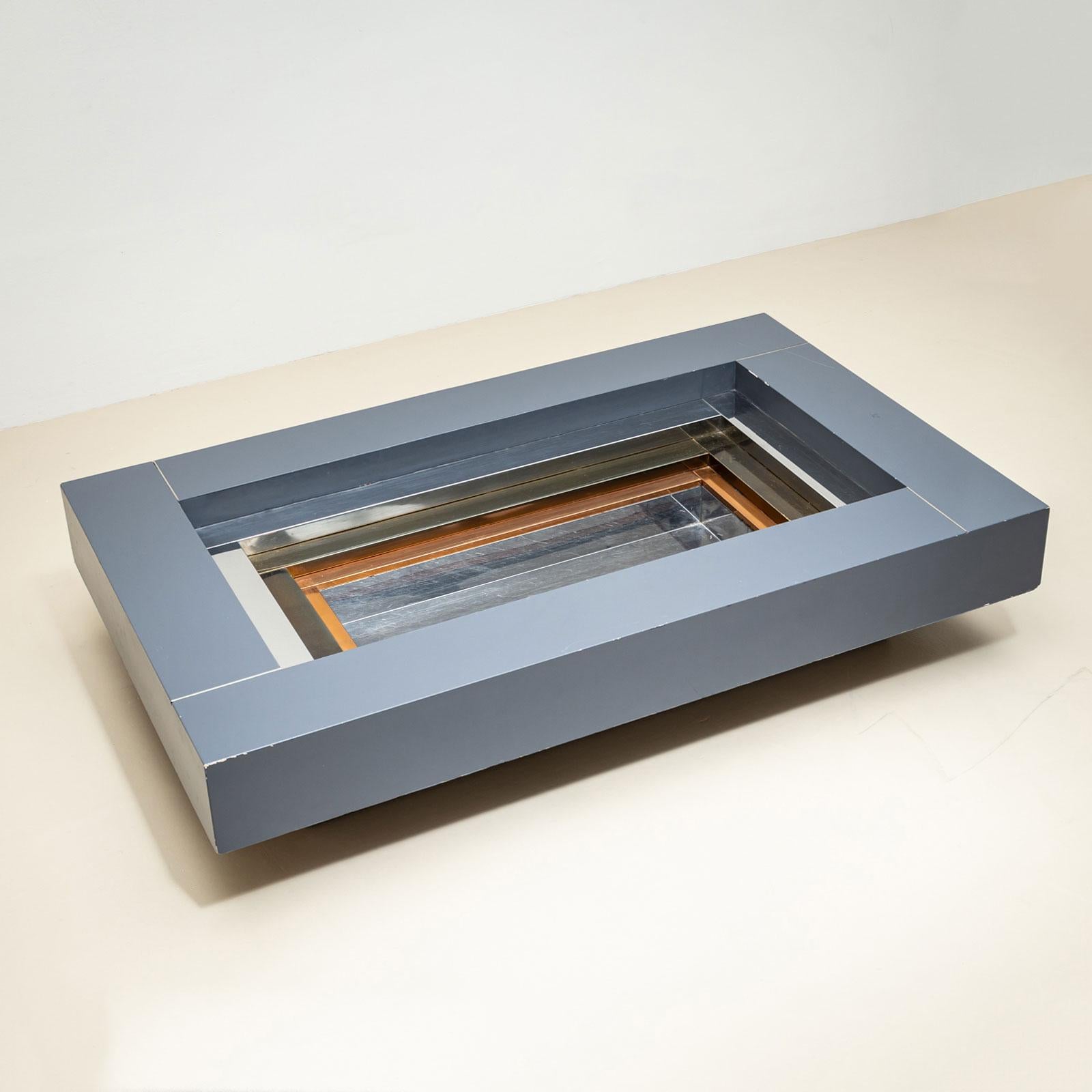 An elegant coffee table designed by Alain Delon (French, 1935–2024) for the renowned Parisian furniture house Maison Jansen. The table features a rectangular shape with a stepped design that descends towards the center. Each step is crafted from a