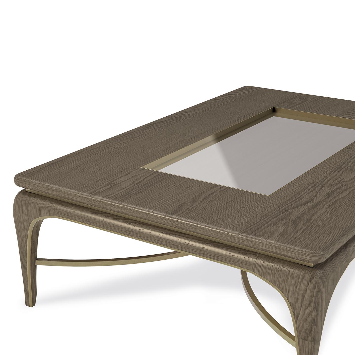 Unique and elegant, this rectangular coffee table is exquisitely crafted with meticulous attention to detail. The structure is made of veneered plywood, while the frame and base are in solid wood and are enriched with a burnished brass profile