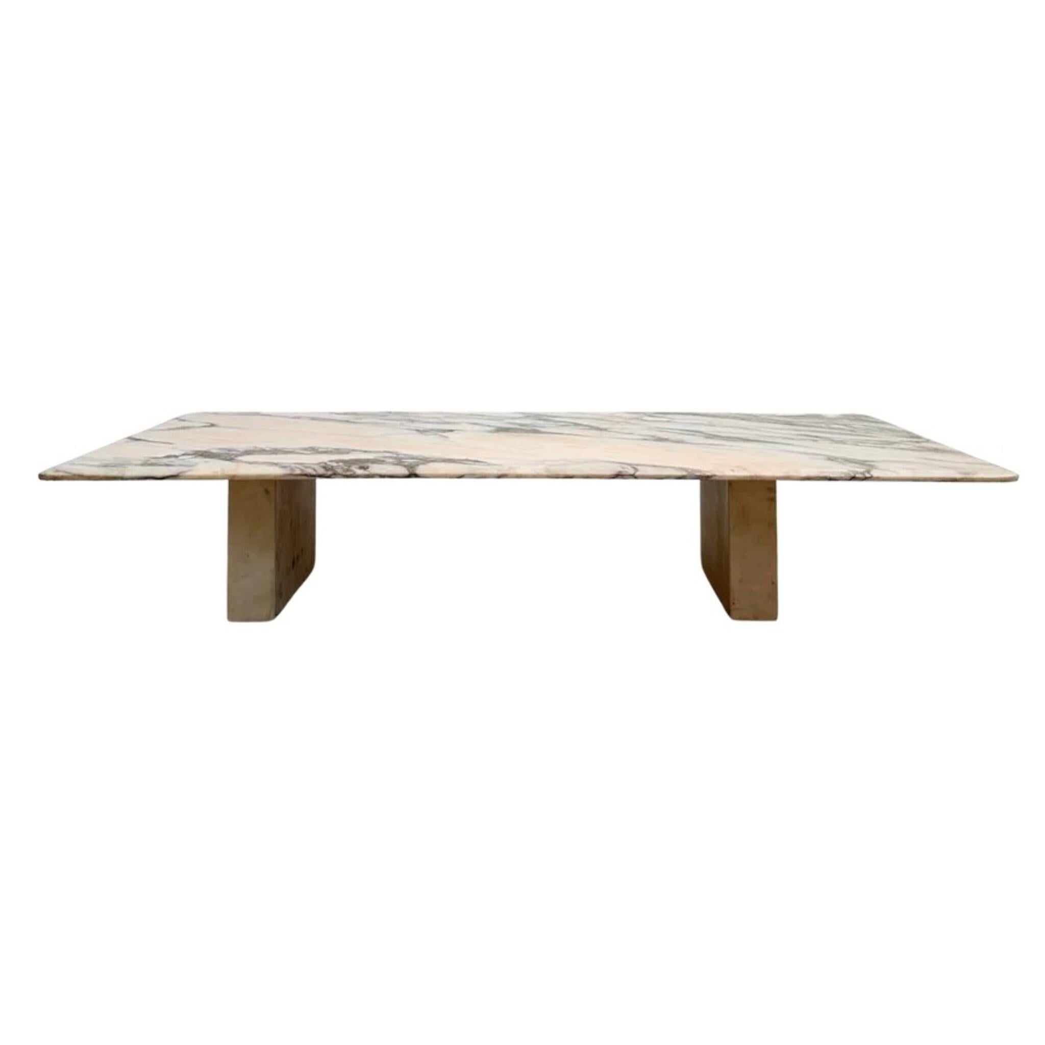 Rectangular coffee table in rare pink Arabescato marble of Spanish origin. The surface features dramatic veining in blush, peach, and charcoal that evokes a painterly, almost abstract quality. The substantial slab top rests on squared marble block