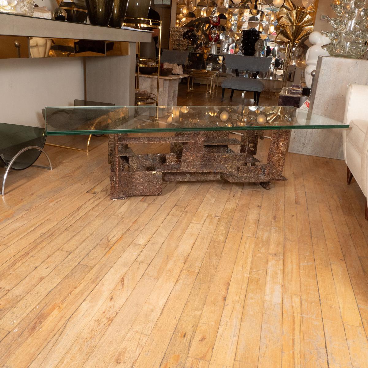 Rectangular coffee table with glass top and iron sculpted base in the style of Paul Evans. 