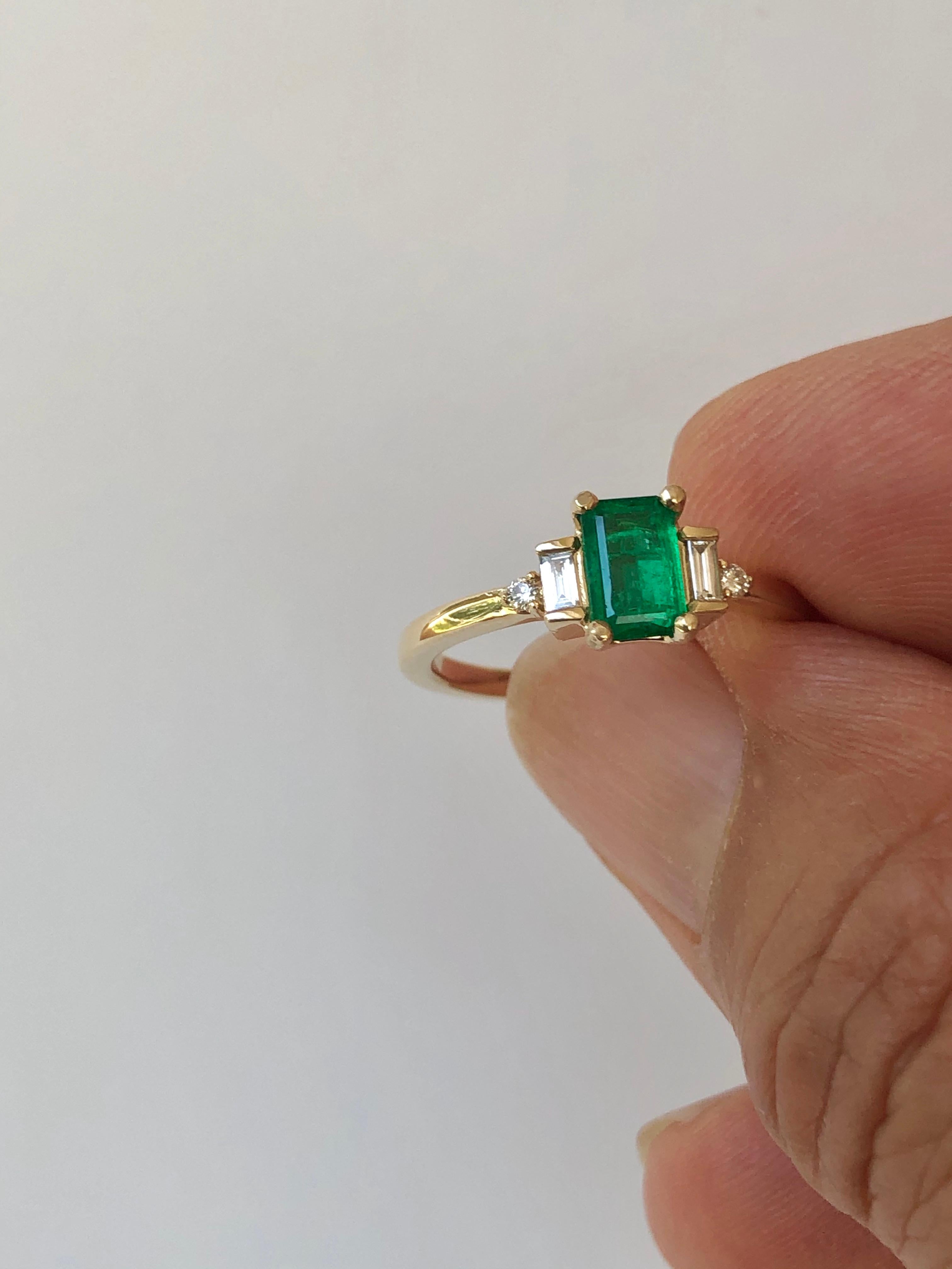 This is a Gorgeous Colombian Emerald and Diamond Engagement Ring set with a rectangular cut emerald weighing approximately .50 carats (6.5x4.2mm), within two emerald cut and round cut diamonds H/SI1 weighing approximately  .10 carats. Set in yellow