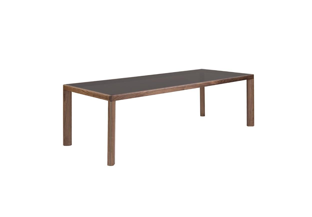 This rectangular dining table features a robust solid wood structure paired with a high quality stoneware top. The table exudes elegance and refinement, inspired by minimalist lines and highlighted by well-crafted details and premium materials. The