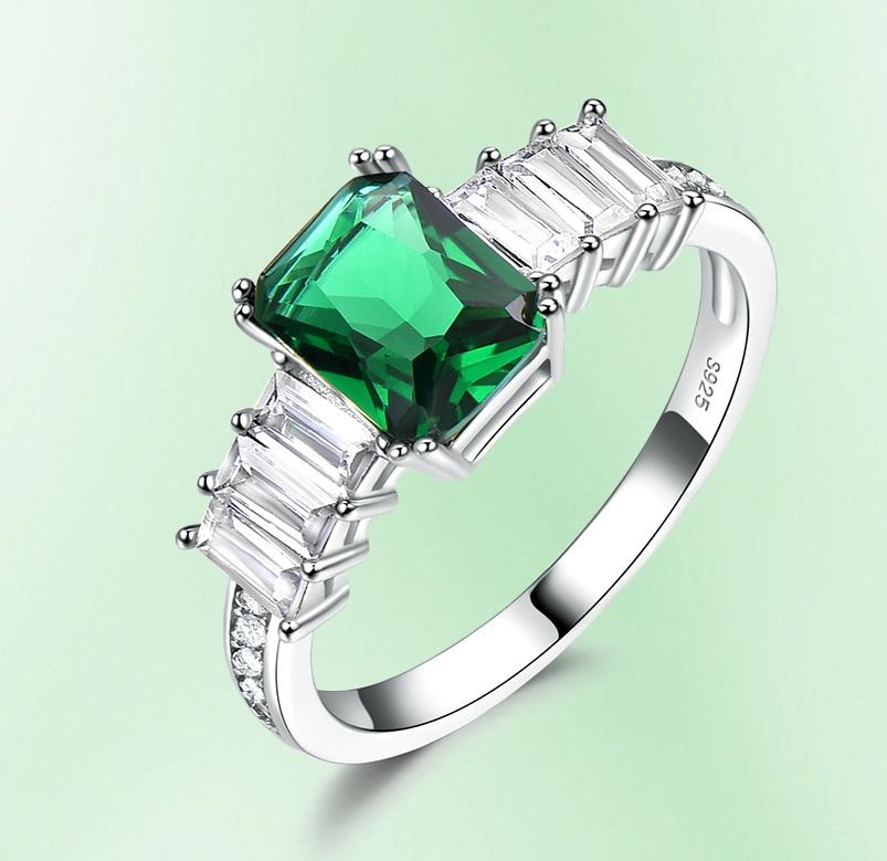 An Octagonal 6 x 8 Rectangular Emerald Green Cubic Zirconia with Three White Emerald-Cut Side Stones on each side, Sterling Silver Ring 
Available in Ring Size 6 & 7.
Triple AAA white and colored cubic zirconia.
Total Weight: 2.54 grams

