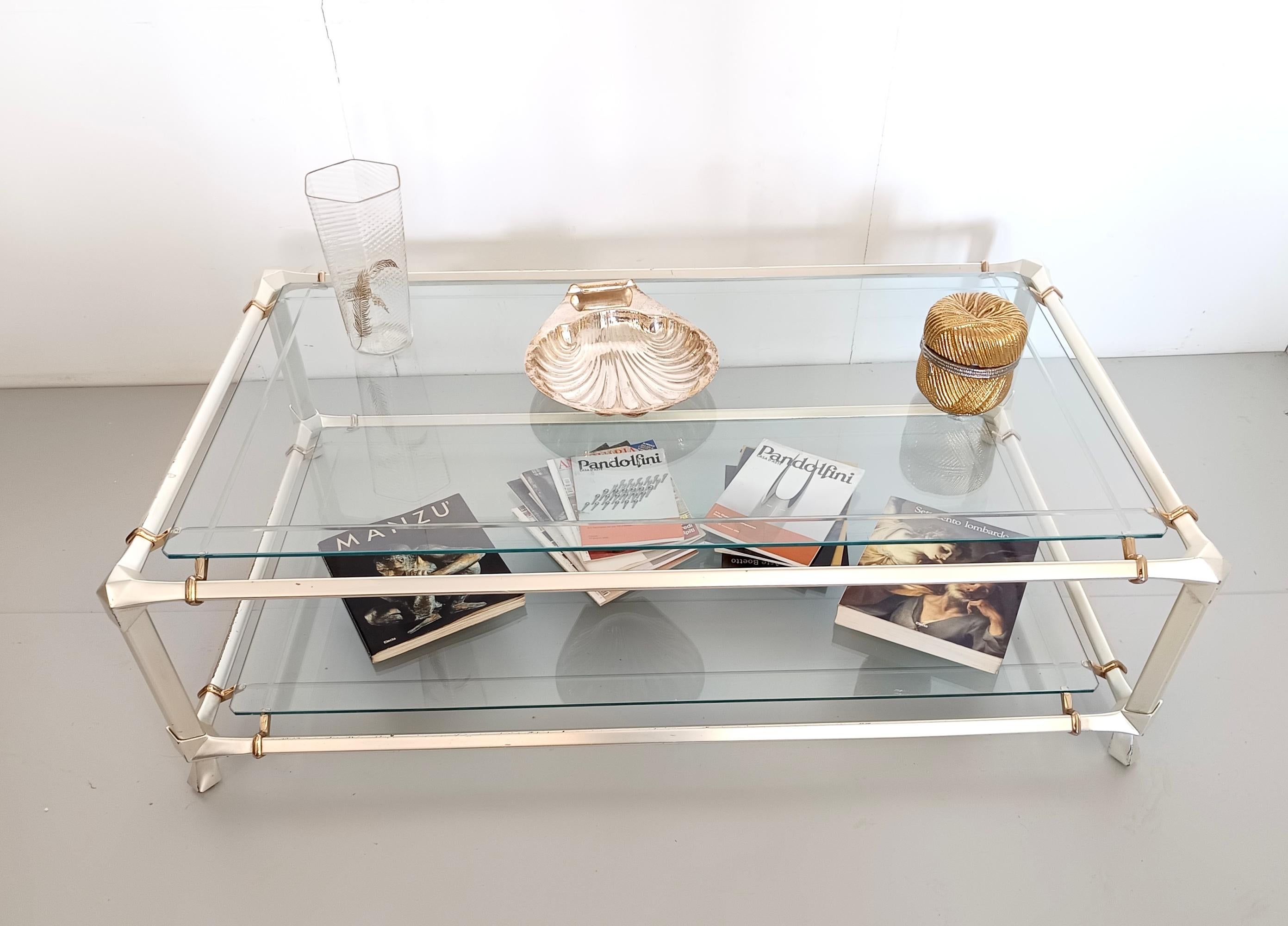 Made in Italy, 1990s. 
This beautiful table features a white anodized metal frame and a clear cut and engraved crystal top and lower shelf.
It is a vintage item, therefore it might show light traces of use such as on the metal parts. Overall, it can