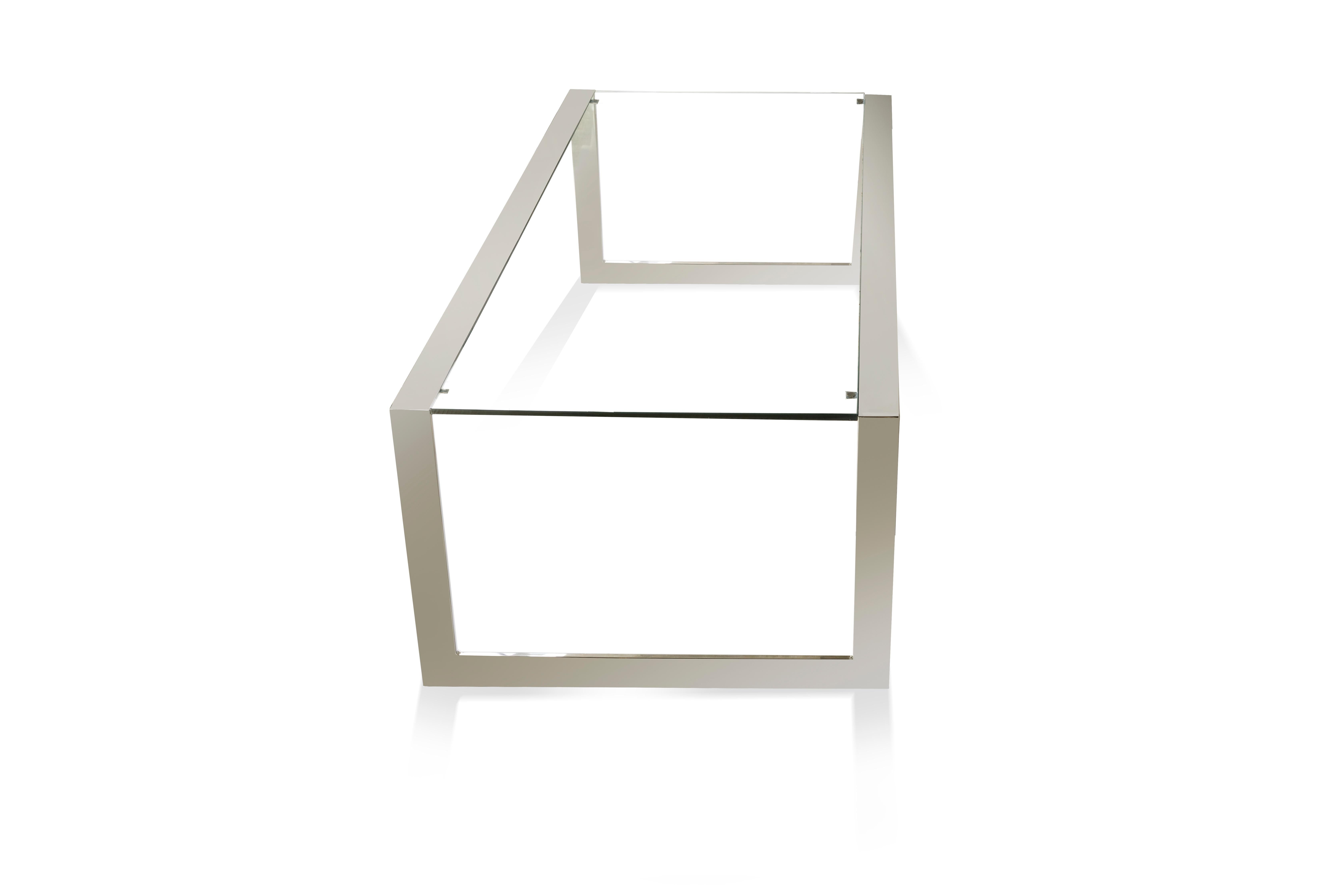 BARCELONA is a coffee table made in stainless steel and glass. The thin metal tracks are seamlessly connected and define the very clean shape of this contemporary coffee table. The glass can be clear or in any other shades to blend into the