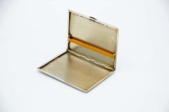 Etui à cigarettes rectangulaire en argent guilloché avec couvercle à ressort et intérieur doré.