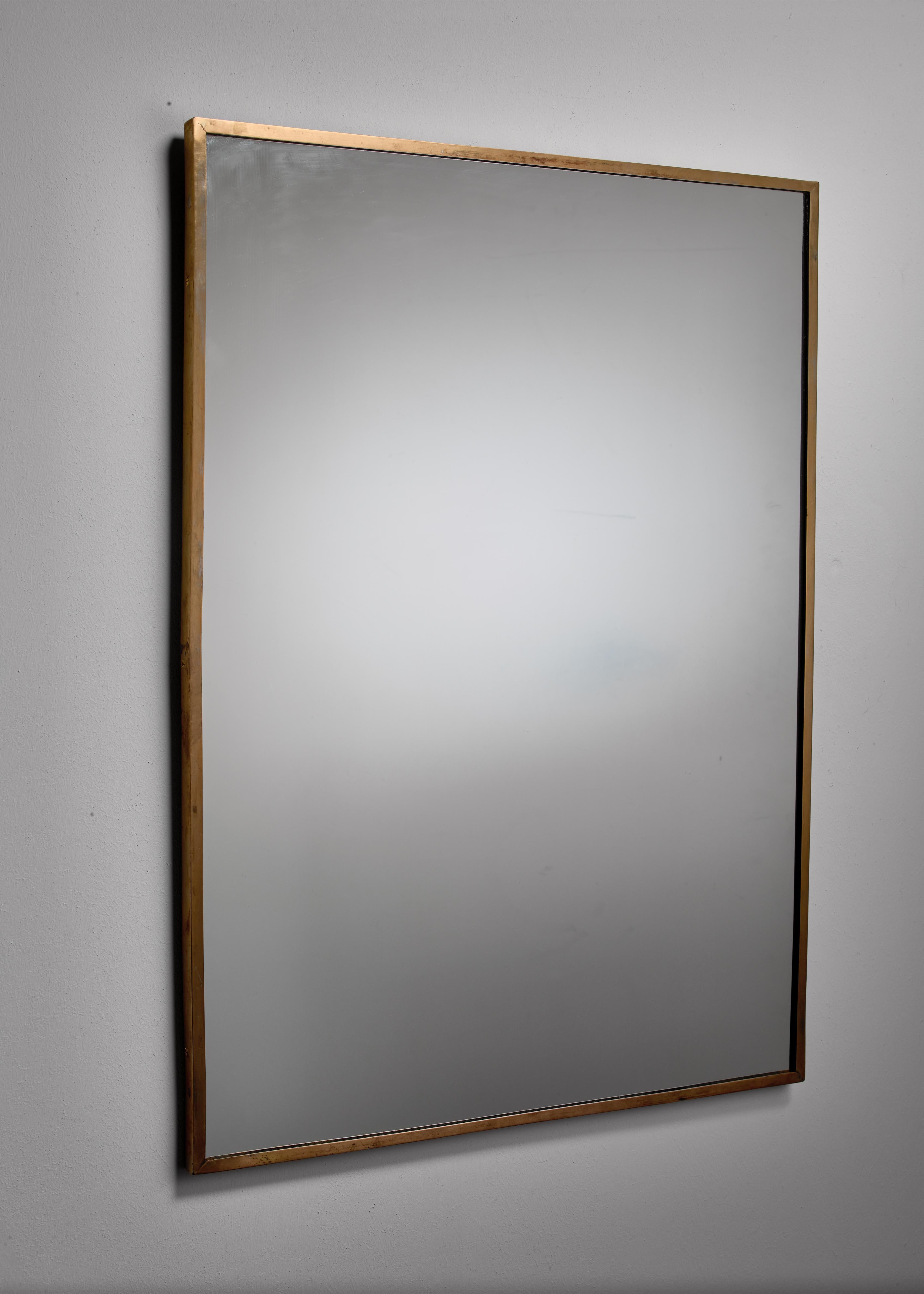 A rectangular Italian wall or overmantel mirror with a brass frame on a wooden base. A simple and elegant design and in good vintage condition. 
 We have several other brass wall mirrors available in various sizes.