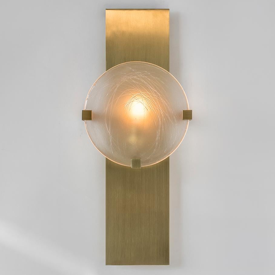 The LUNETTE Wall Sconce is composed of a cold rolled steel body with a delicate armature projecting a frosted cast glass diffuser. This sconce is available in a variety of plated finishes and cast glass textures. The LUNETTE Wall Sconce is