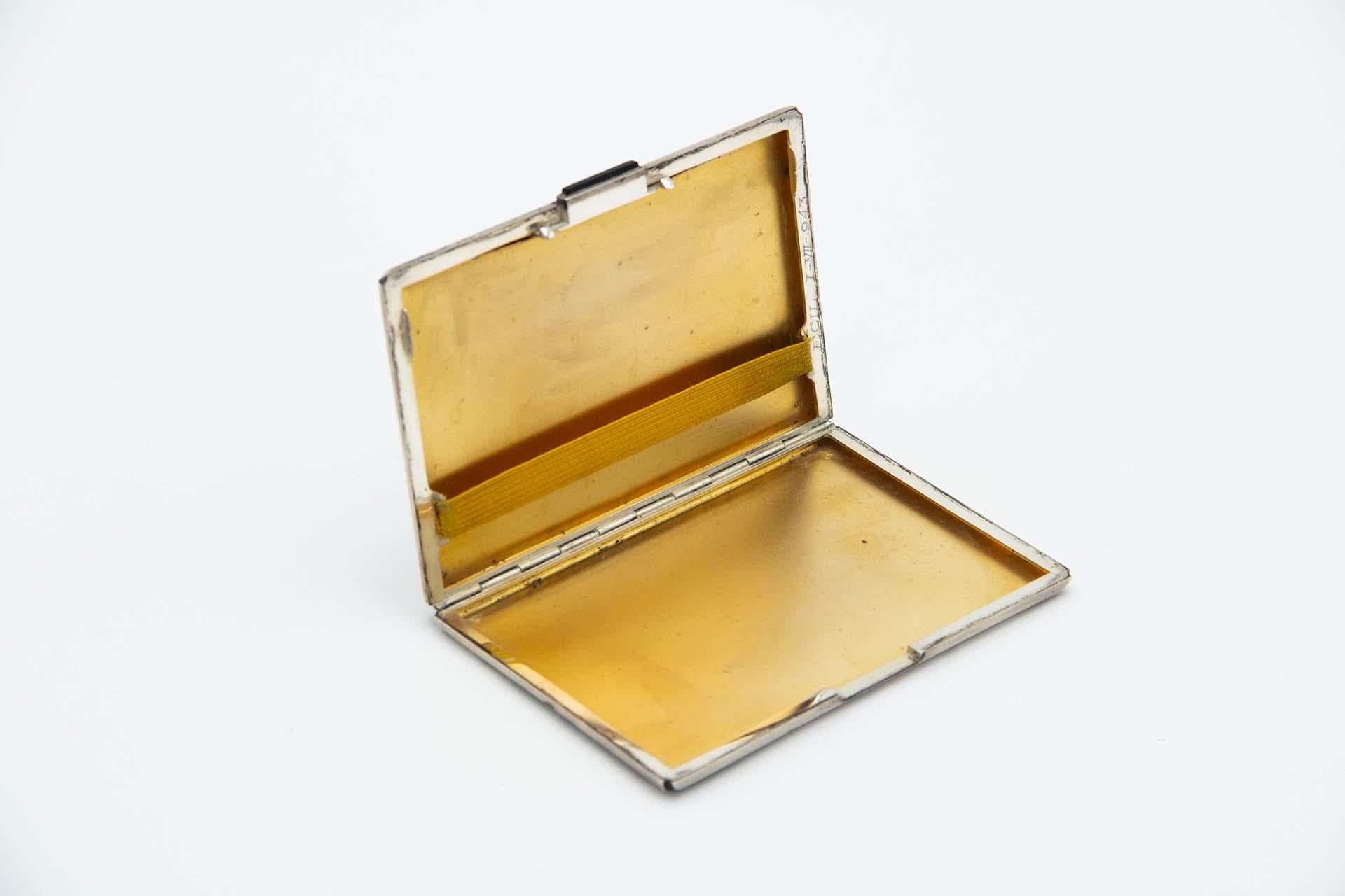 Description: Rectangular cigarette case in matte silver and gilded interior with application on the clasp. Metal: Silver. Origin: Portuguese. Brand: Cabeça de escravo. Weight: 166.99 grams. Dimensions: 11.9cmx1cm. Content: 833/1000. Assay Mark: Yes,