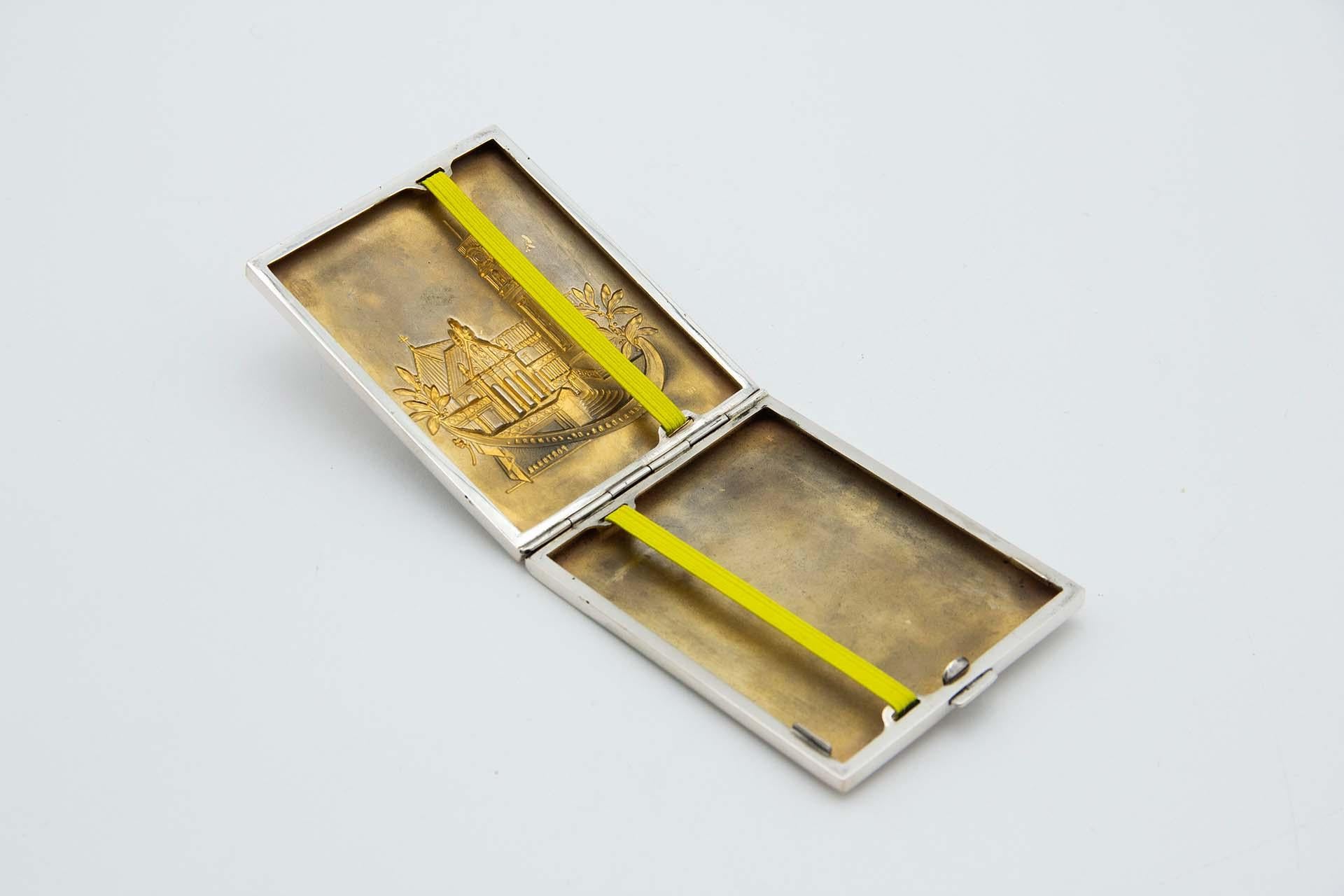 Description : Etui à cigarettes rectangulaire en argent mat avec des reliefs évoquant l'Université de Coimbra. Métal : Argent. Origine : Portugais. Marque : Tête d'aigle. Poids : 132,56 grammes. Dimensions : 10,6 cm x 1,3 cm : 10.6cmx1.3cm. Contenu