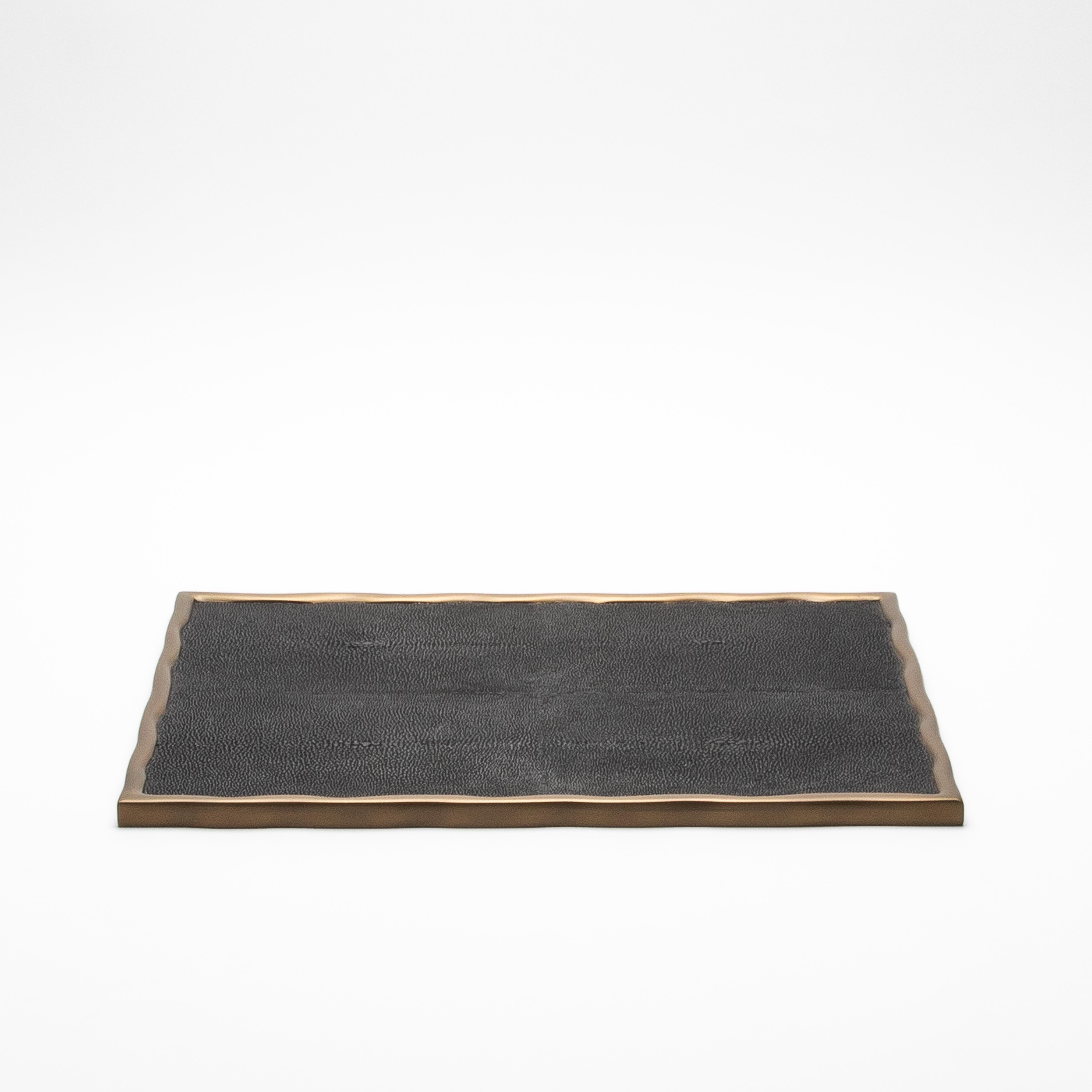 The Rectangular Melting Tray by R&Y Augousti in white shagreen exudes refined sophistication and meticulous craftsmanship. Encased in bronze patina brass with an organically flowing melting border, this tray merges timeless elegance with modern
