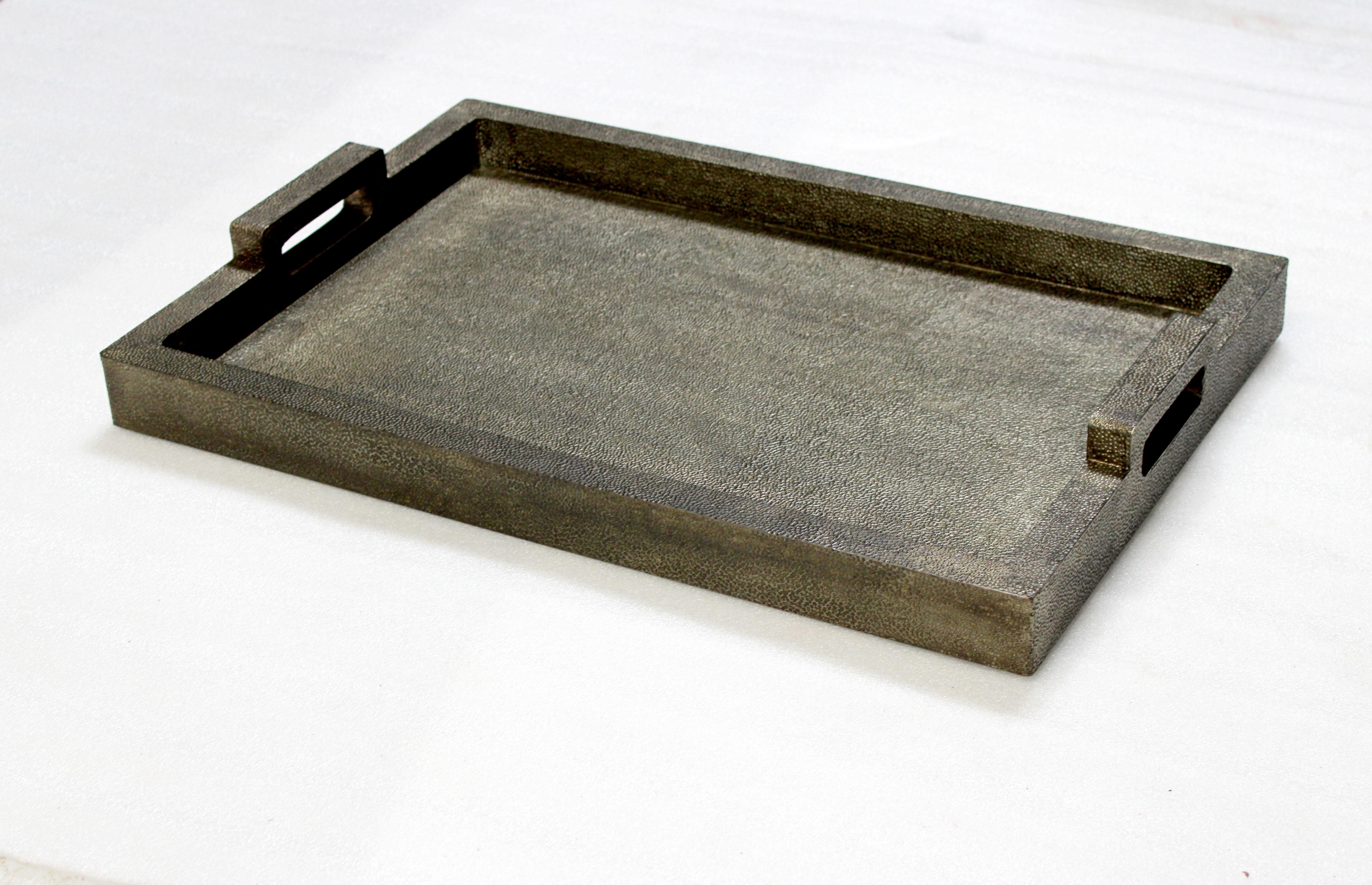 Dieses minimalistische und vielseitige Tablett ist aus hochwertigem, wasserfestem Holzwerkstoff gefertigt, der mit einer traditionellen handwerklichen Technik mit Metall verkleidet ist. Das metallverkleidete Äußere wird dann in sorgfältiger