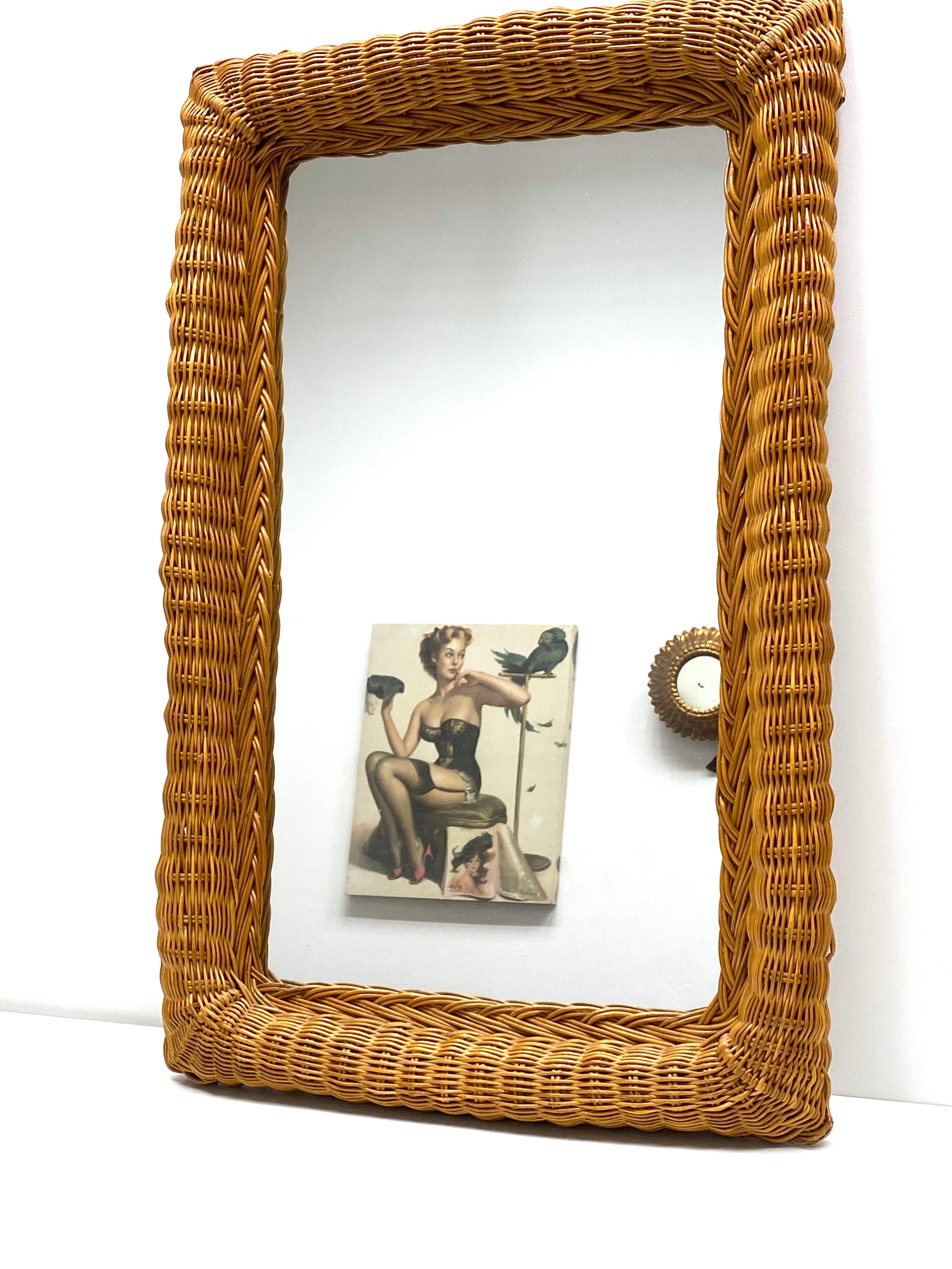 A beautiful handwoven rectangular shaped wicker frame mirror. This mirror has a handcrafted braided work at the frame that makes it highly decorative, Germany, 1960s. Visible mirror size is approx. 22