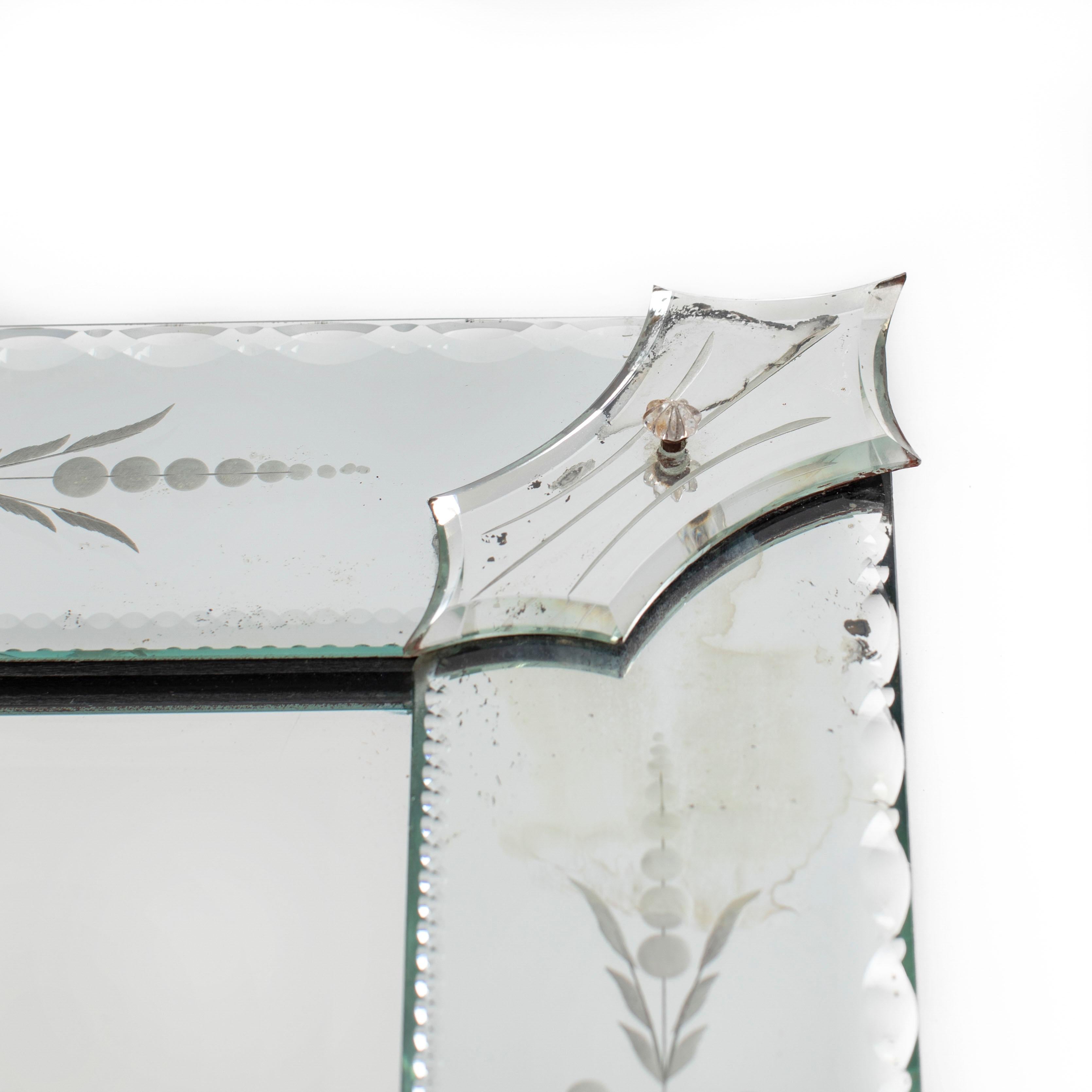 Miroir vénitien rectangulaire à la décoration délicate, France années 1930

L'objet est classique dans sa forme et son design.
Le miroir intérieur présente une facette de 2 cm de large sur le pourtour. Le cadre, d'une largeur de 9,5 cm, est décoré