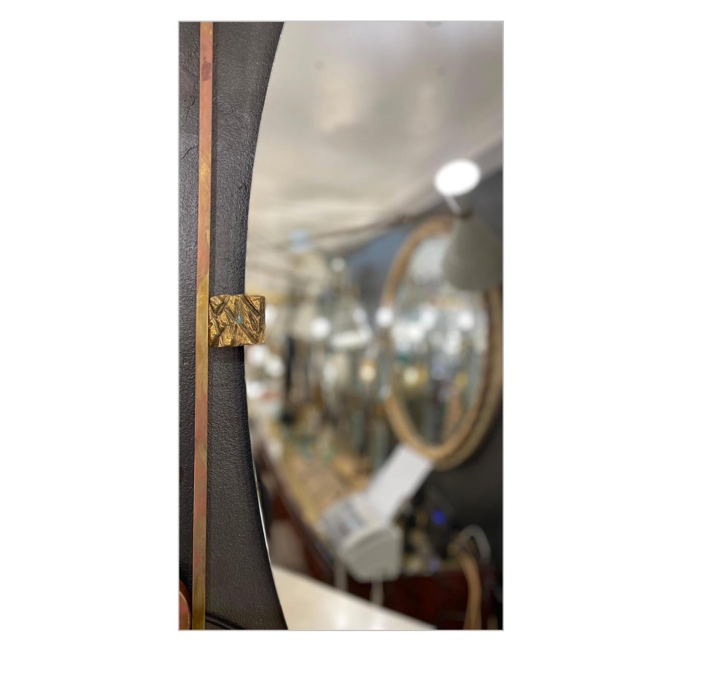 A fantastic Italian mirror in oval shape mounted on a rectangular brass frame, circa 1980.