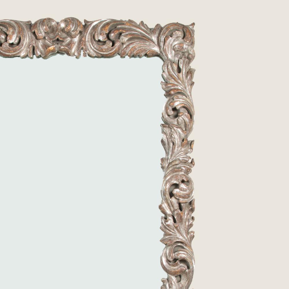 A rectangular mirror with an early 18th century style carved wood and silver gilt frame, 20th century.