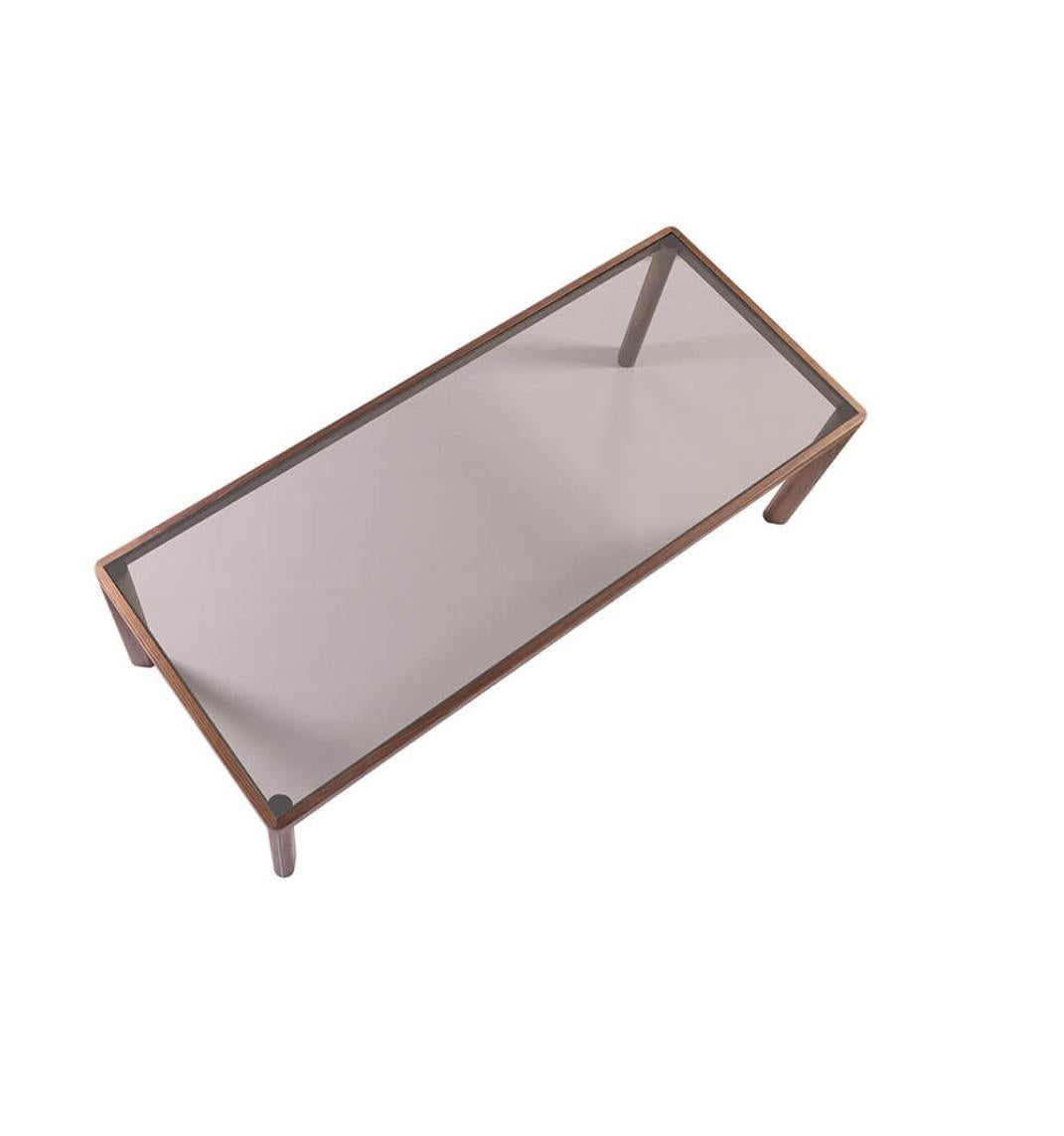 Cette table de salle à manger rectangulaire présente une structure robuste en bois massif associée à un plateau en verre. La table respire l'élégance et le raffinement, inspirée par des lignes minimalistes et mise en valeur par des détails bien