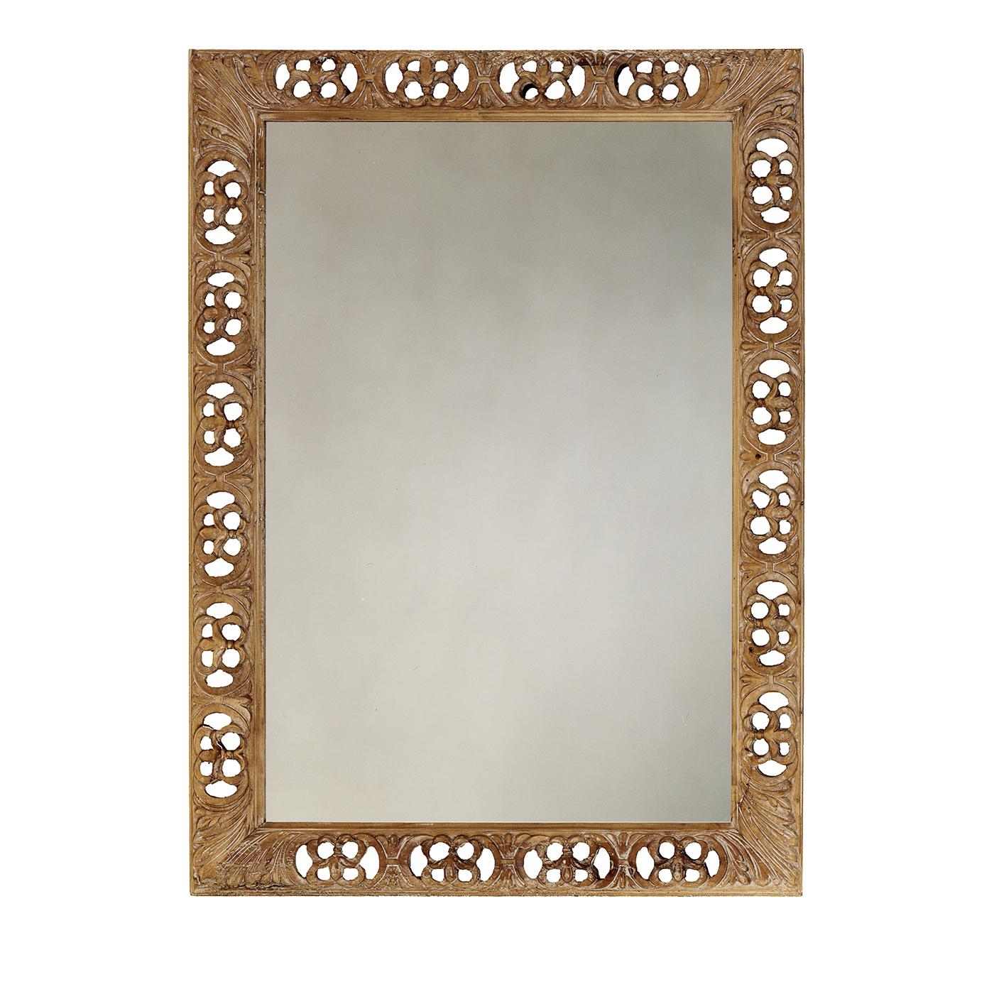 This unique mirror is a stunning example of exquisite craftsmanship. The rectangular mirror is adorned with a frame in sold wood with an openwork decoration made by hand and embellished with carved elements at the corners in the shape of
