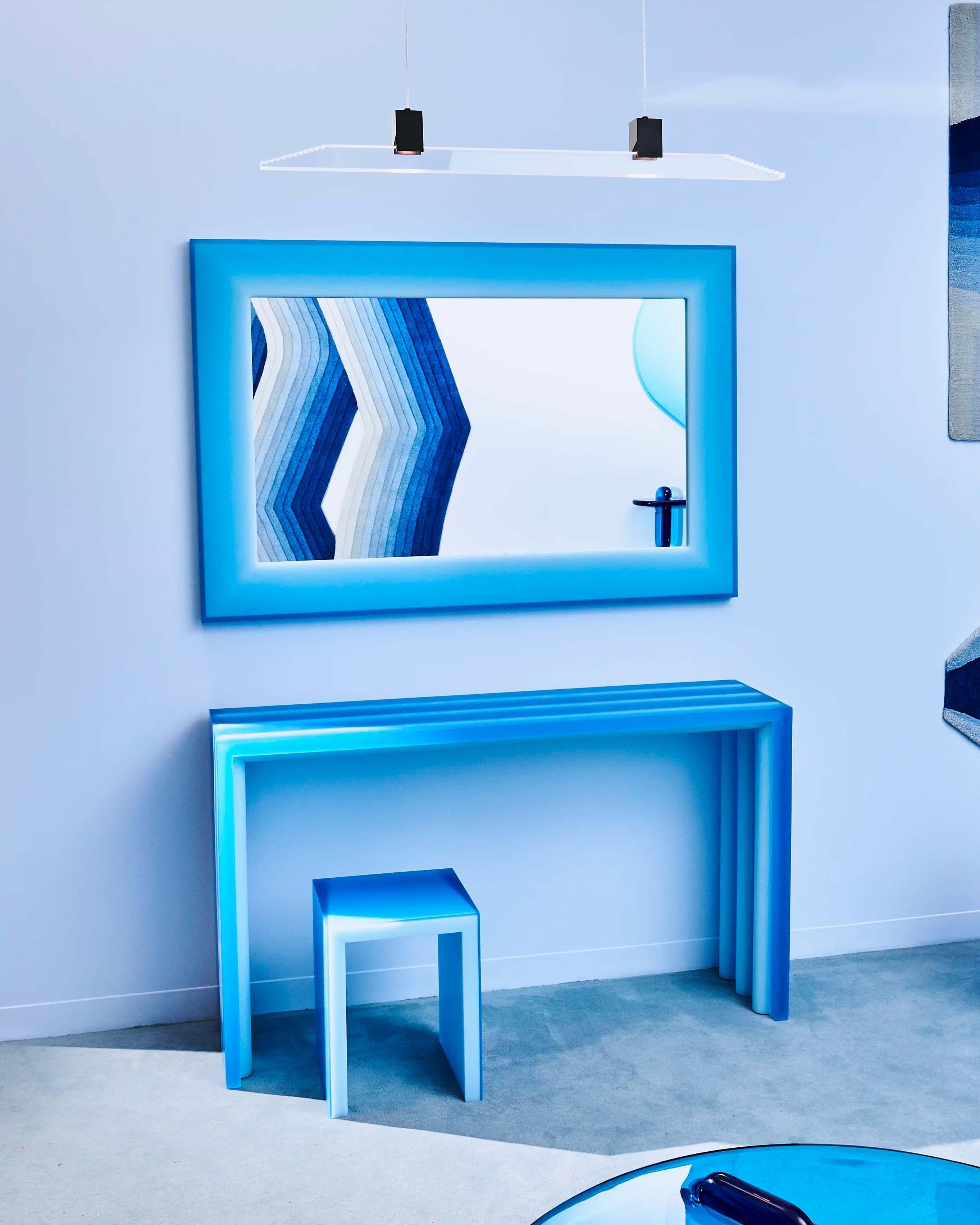 Unique wall mirror with a resin sculpted frame to create a smooth and luminous sky-liked surface. The technique creates an illusion of a glowing effect, featuring a subtle saturation shift on the blue spectrum by manipulating the visual interaction