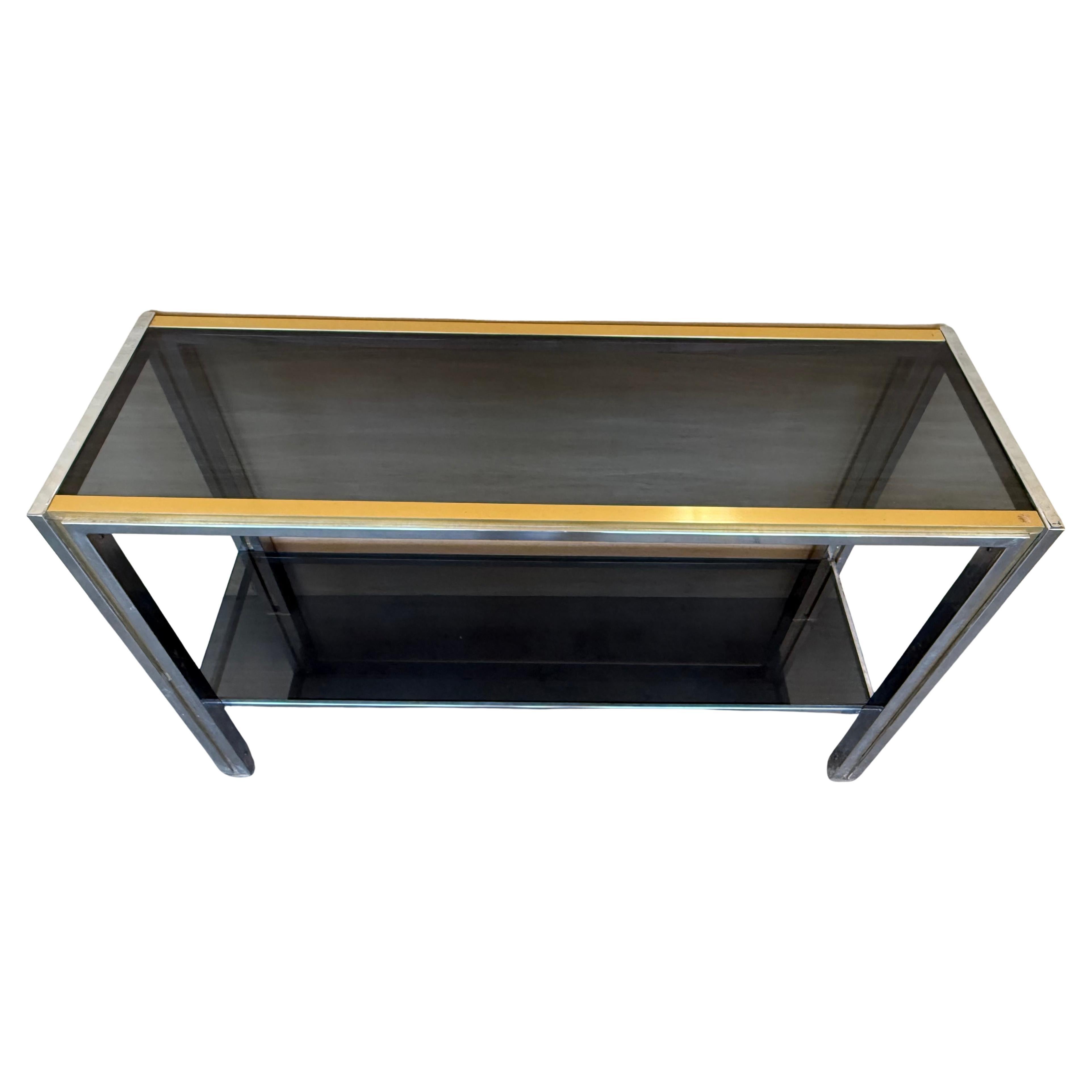 Table console de style Régence hollywoodienne, Romeo Rega, Italie, années 1970.  Le cadre sculptural en chrome et laiton contraste joliment avec le plateau en verre fumé, maintenu par des détails en plexiglas violet. Décoration éclectique de style
