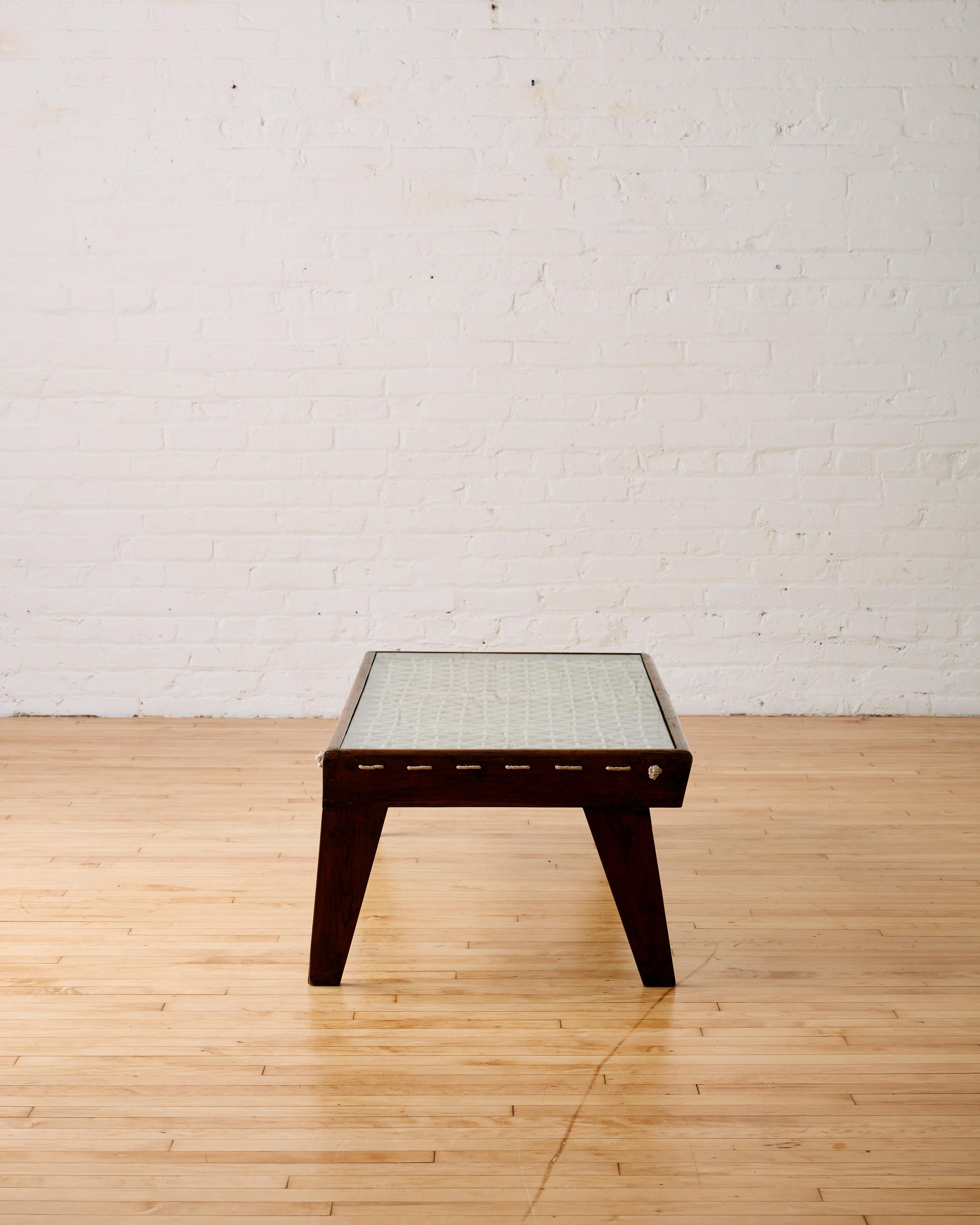 Rare table basse rectangulaire en corde de Pierre Jeanneret, vers les années 1960, fabriquée en bois de teck avec quatre pieds effilés. Il se compose d'un plateau de table en verre avec des détails en corde tressée en dessous, disposés en