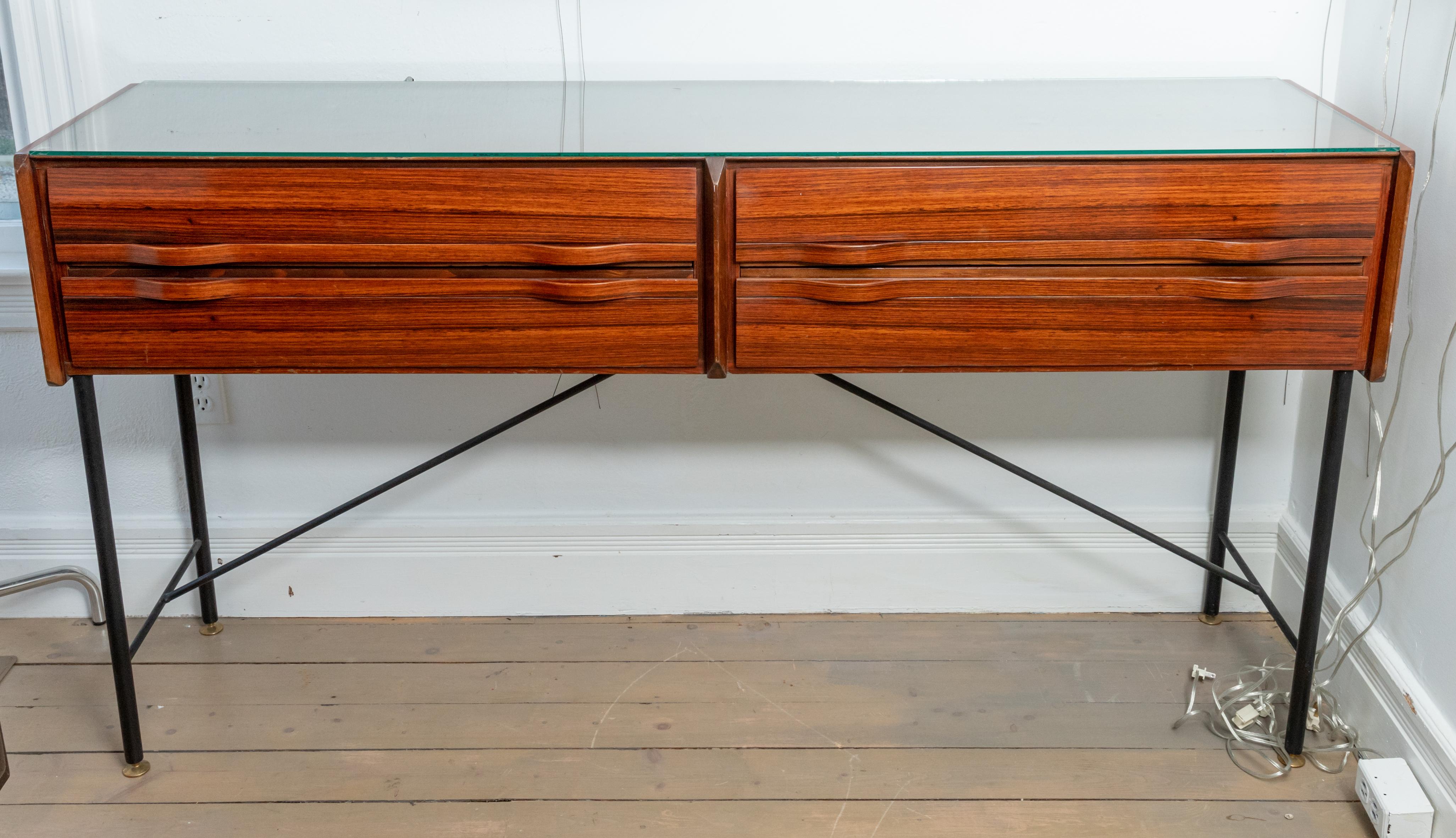 Rectangular rosewood four drawer sideboard/console with blackened iron supports, brass detail and glass top.