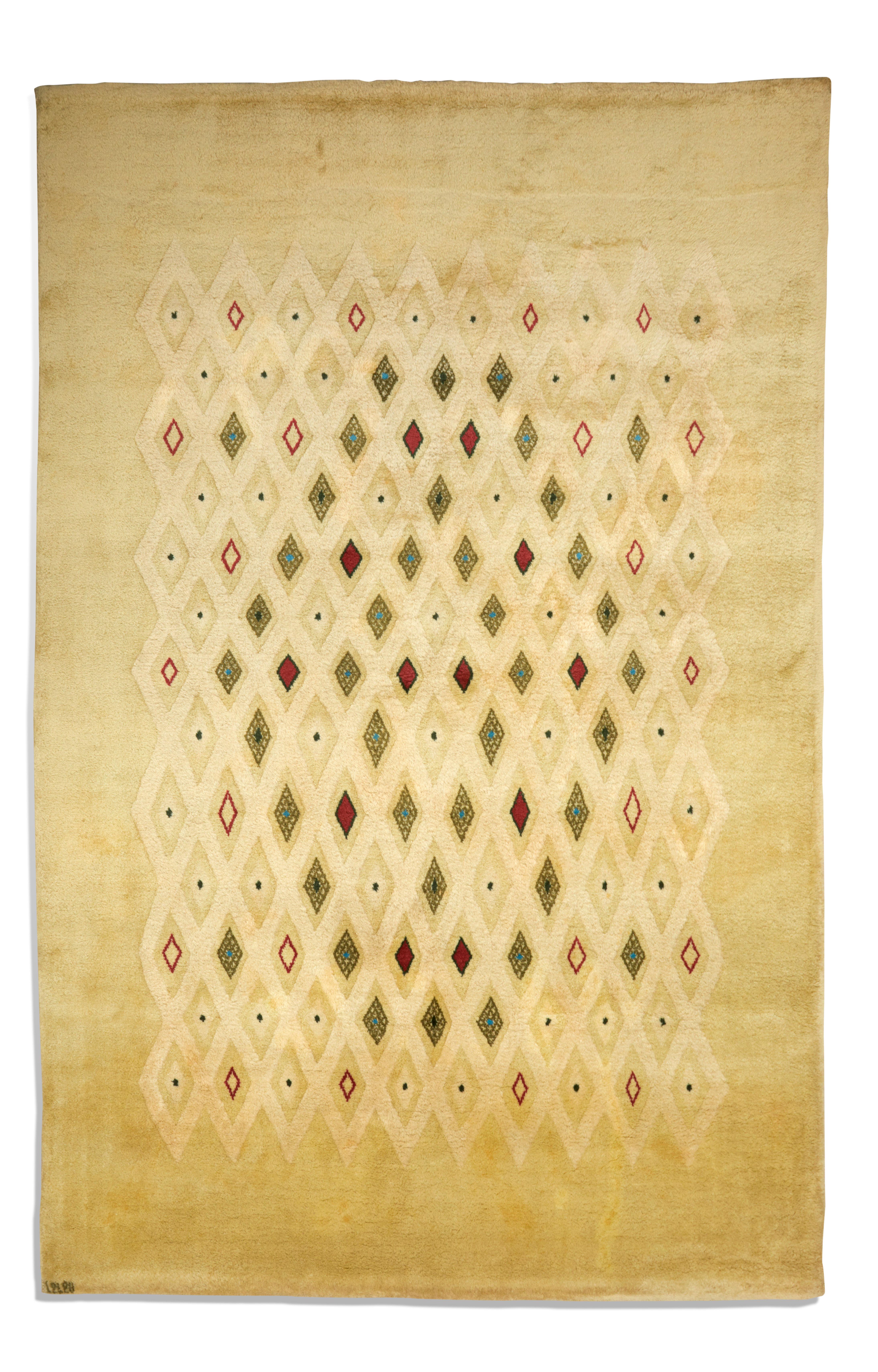 Large rectangular woollen rug with polychrome diamond decoration on a cream background.
Signed lower left 