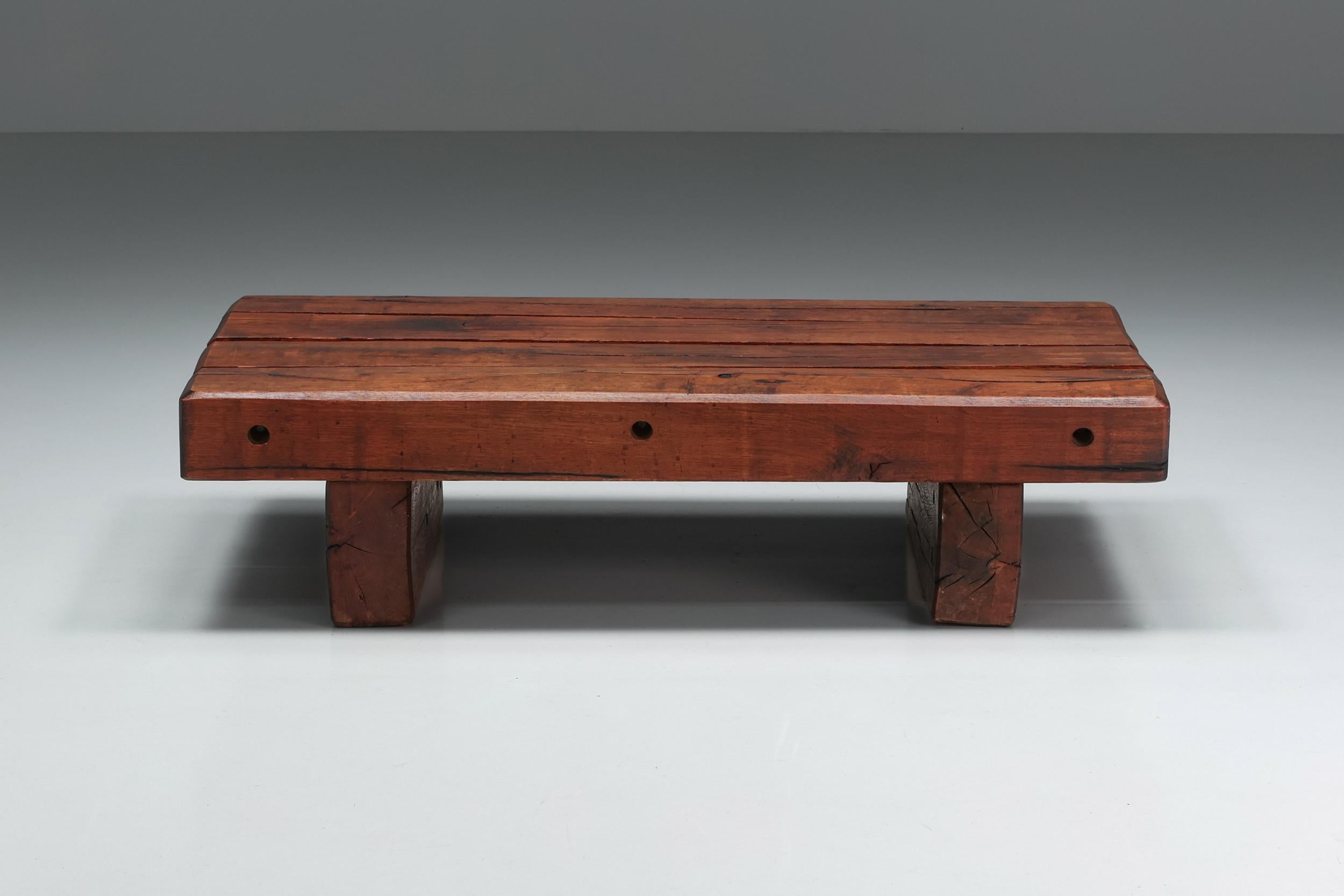 Rustic wooden coffee table made in Italy in the 1940s. The tabletop is connected to two wooden feet that make up the base of the coffee table. The tabletop has three perfectly crafted wholes in them on the side. The charismatic patina shows the