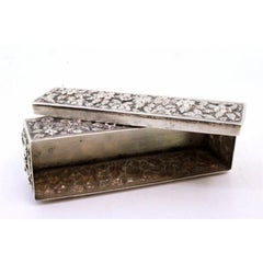 Rectangular silver box with raised floral motifs