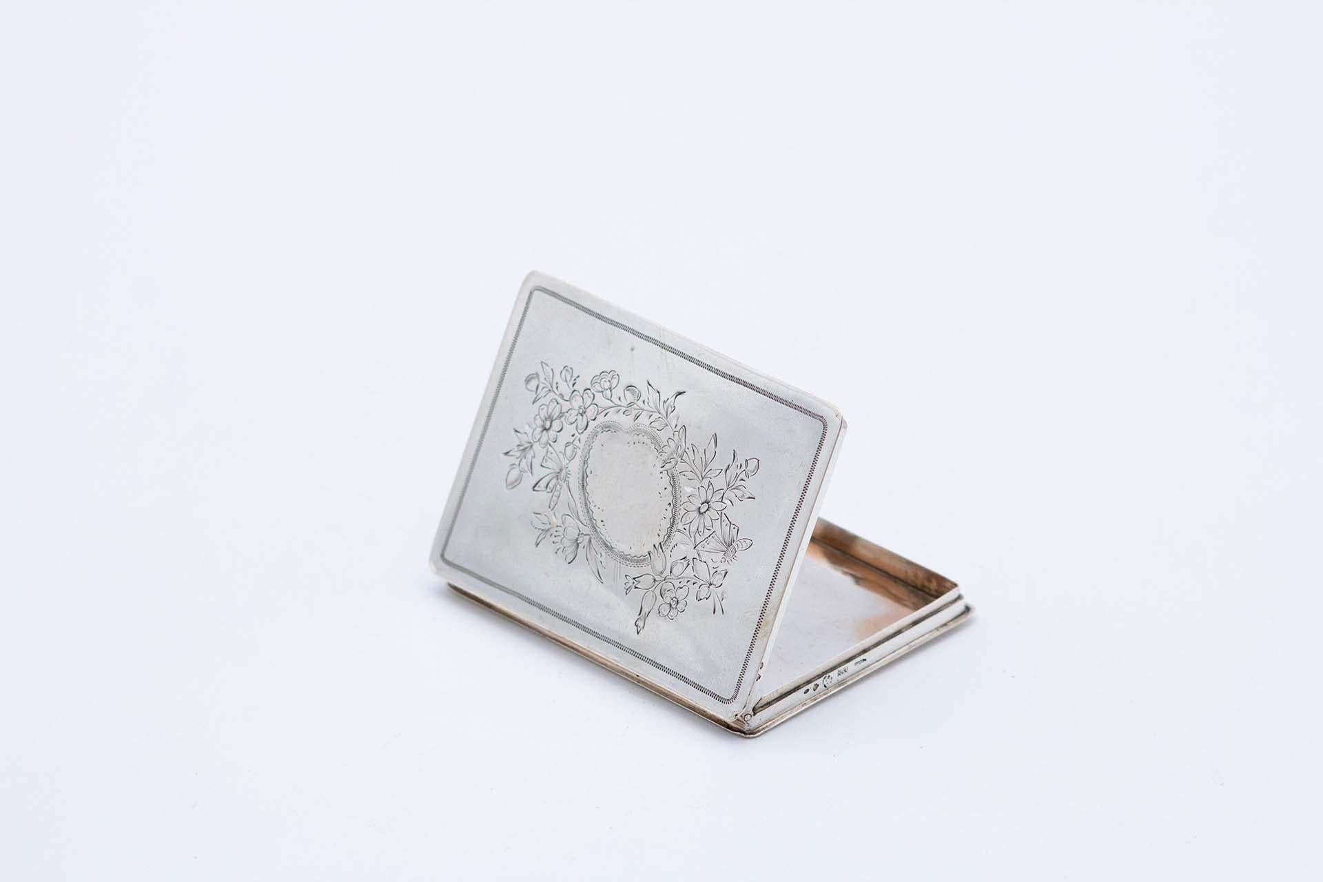 Description: Rectangular silver card case with engraved floral motifs surrounding a monogram card. Metal: Silver. Origin: Portuguese. Brand: javali II Title. Weight: 62.55 grams. Dimensions: 8.7cmx0.8cm. Content: 833/1000. Assay Mark: Yes, between