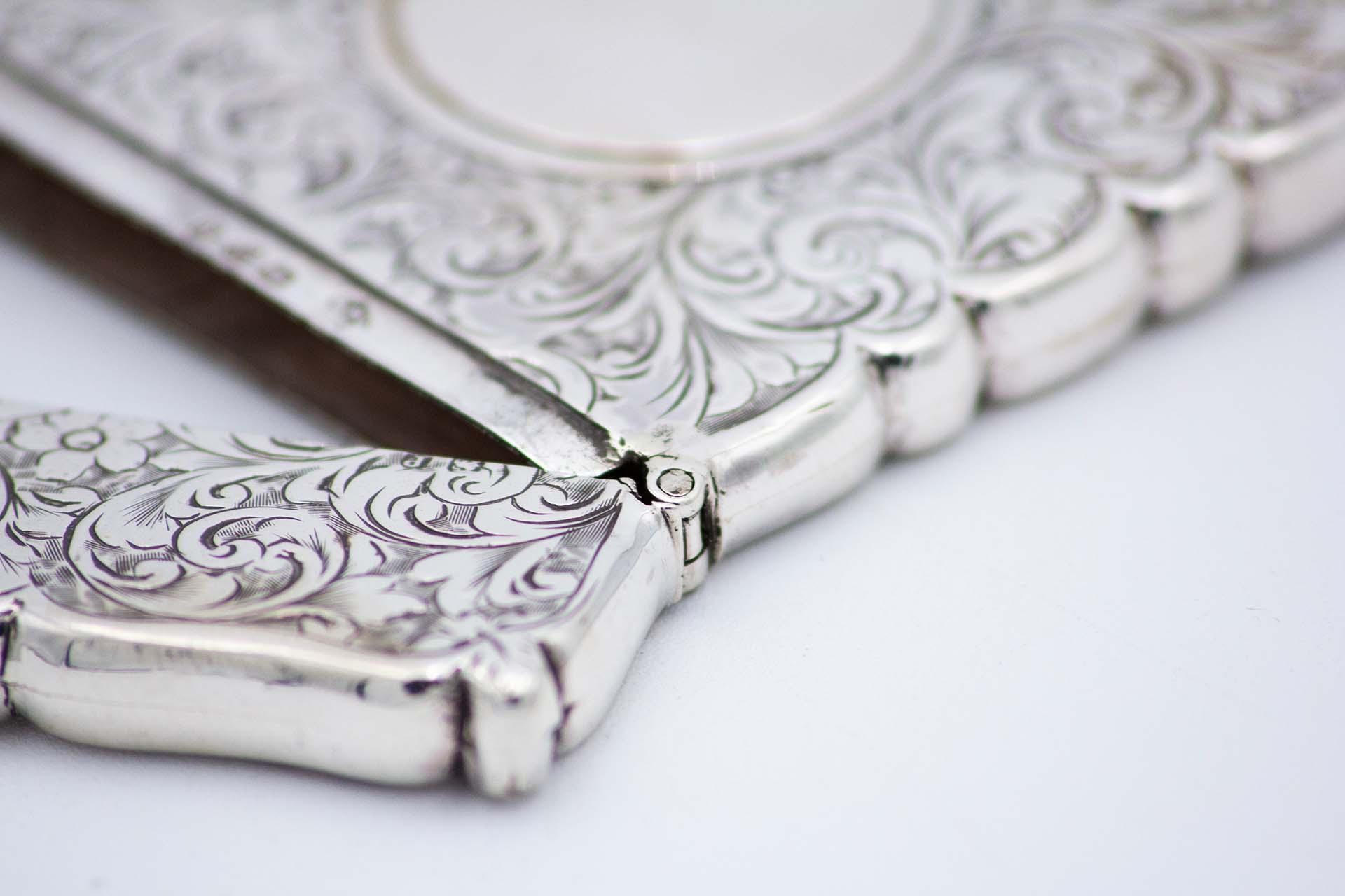 Description: Rectangular silver card case with engravings surrounding a monogram card. Metal: Silver. Origin: English. Brand: Chester. Weight: 59.23 grams. Dimensions: 9.3cmx0.7cm. Content: 925/1000. Assay Mark: Yes, 1833 by James Deakin & Sons