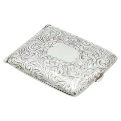 Rectangular silver case with engraved florals, monogram and spring lid