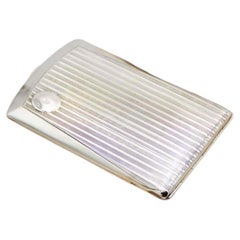 Rectangular silver case with lengthwise strips and spring-loaded lid