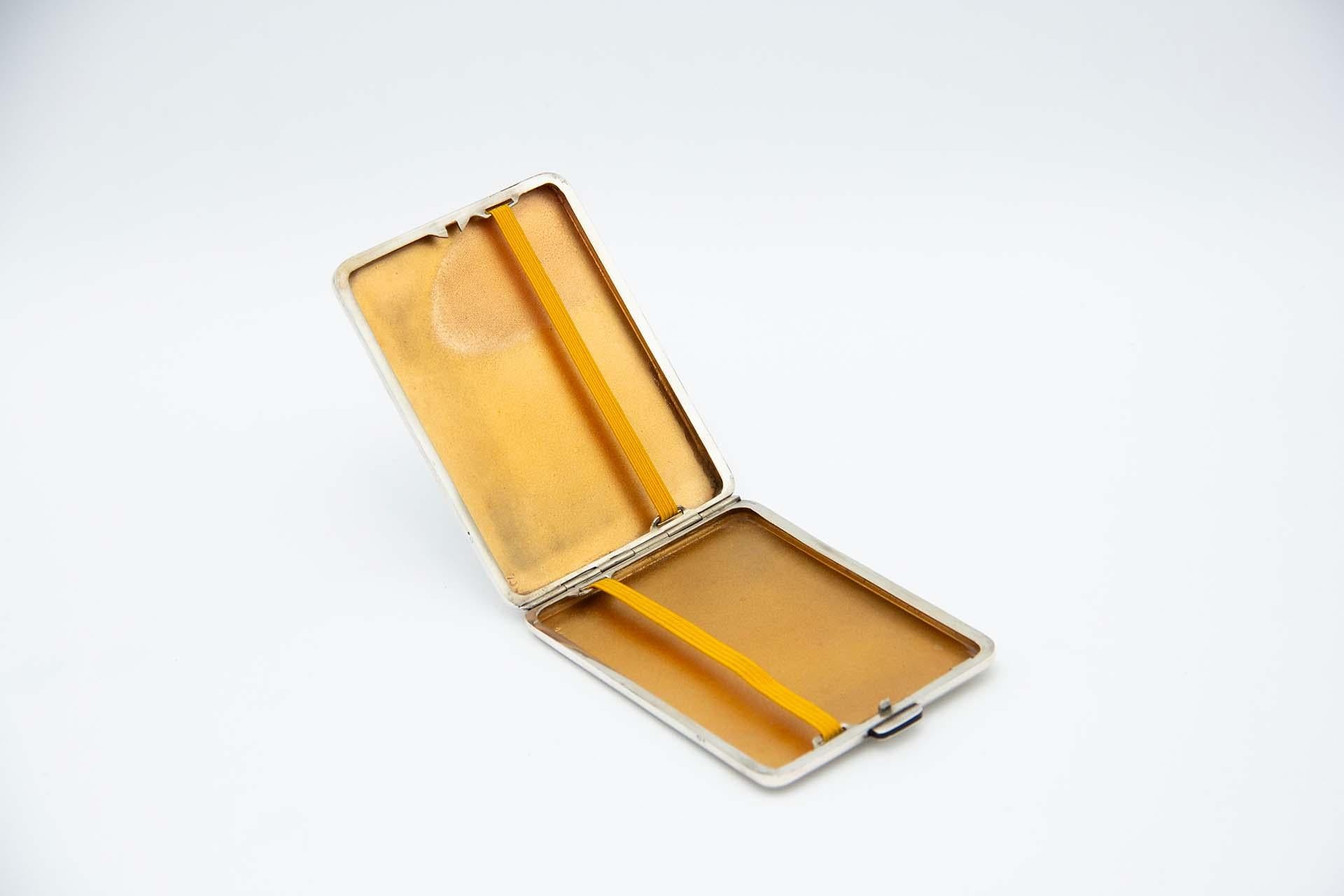 Beschreibung: Rechteckiges silbernes Zigarettenetui mit eingravierten geometrischen Elementen, die eine Karte mit Monogramm umgeben, und goldener Innenausstattung. Metall: Silber. Herkunft: Portugiesisch. Marke: Eagle Head. Gewicht: 89,70 Gramm.