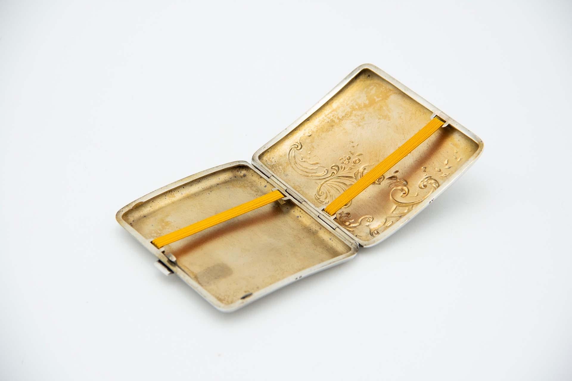 Description : Etui à cigarettes en argent de forme rectangulaire et incurvée, avec des reliefs sur le couvercle dans le style Art Nouveau. Métal : Argent. Origine : Portugais. Marque : javali II Titre. Poids : 87,45 grammes. Dimensions : 8,9 cm x
