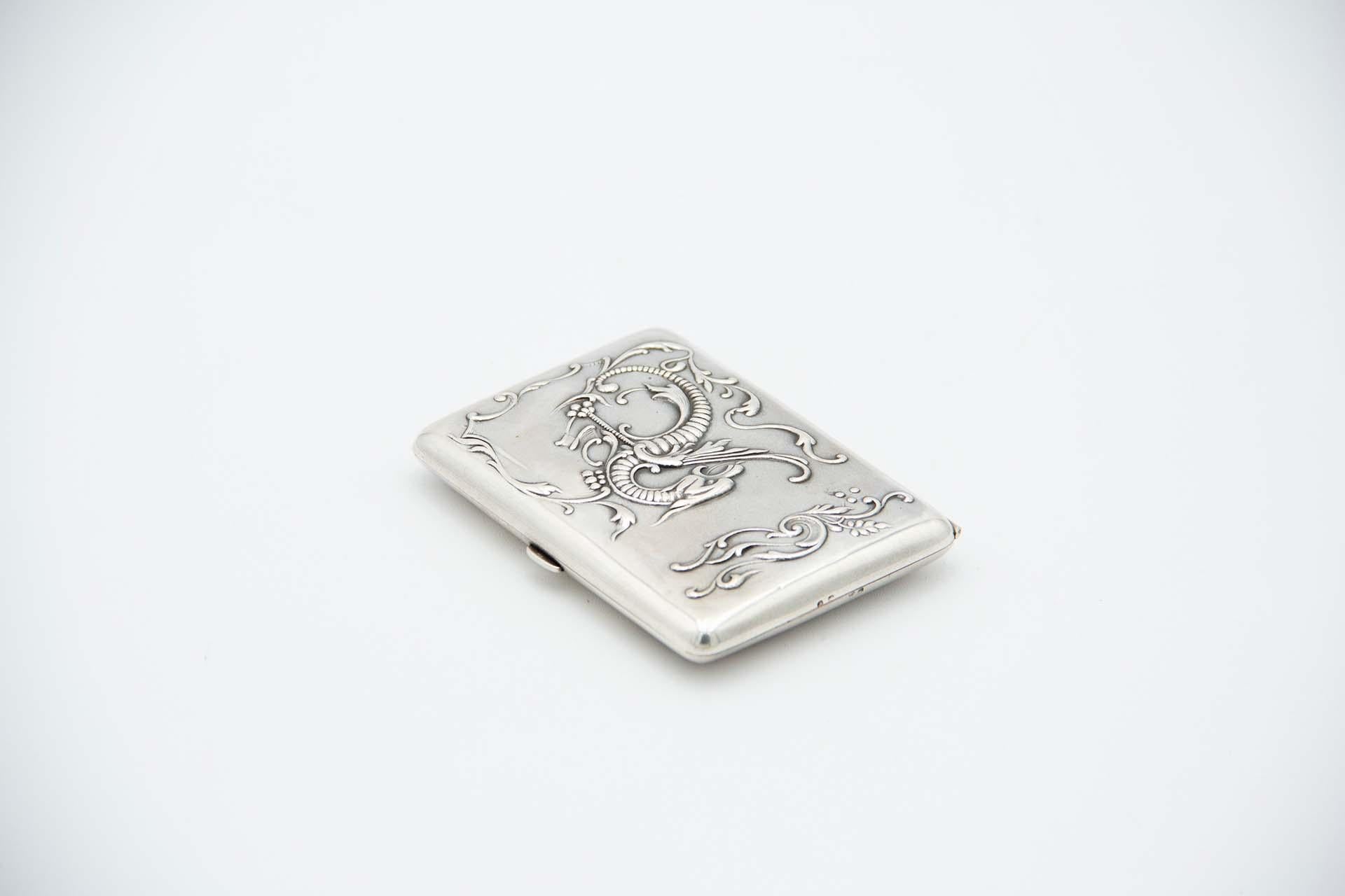 Description: Silver cigarette case in rectangular shape, embossed in the Art Nouveau style, with a hinged lid and spring. Metal: Silver. Origin: Portuguese. Brand: javali II Title. Weight: 59.03 grams. Dimensions: 8.8cmx1.3cm. Content: 833/1000.
