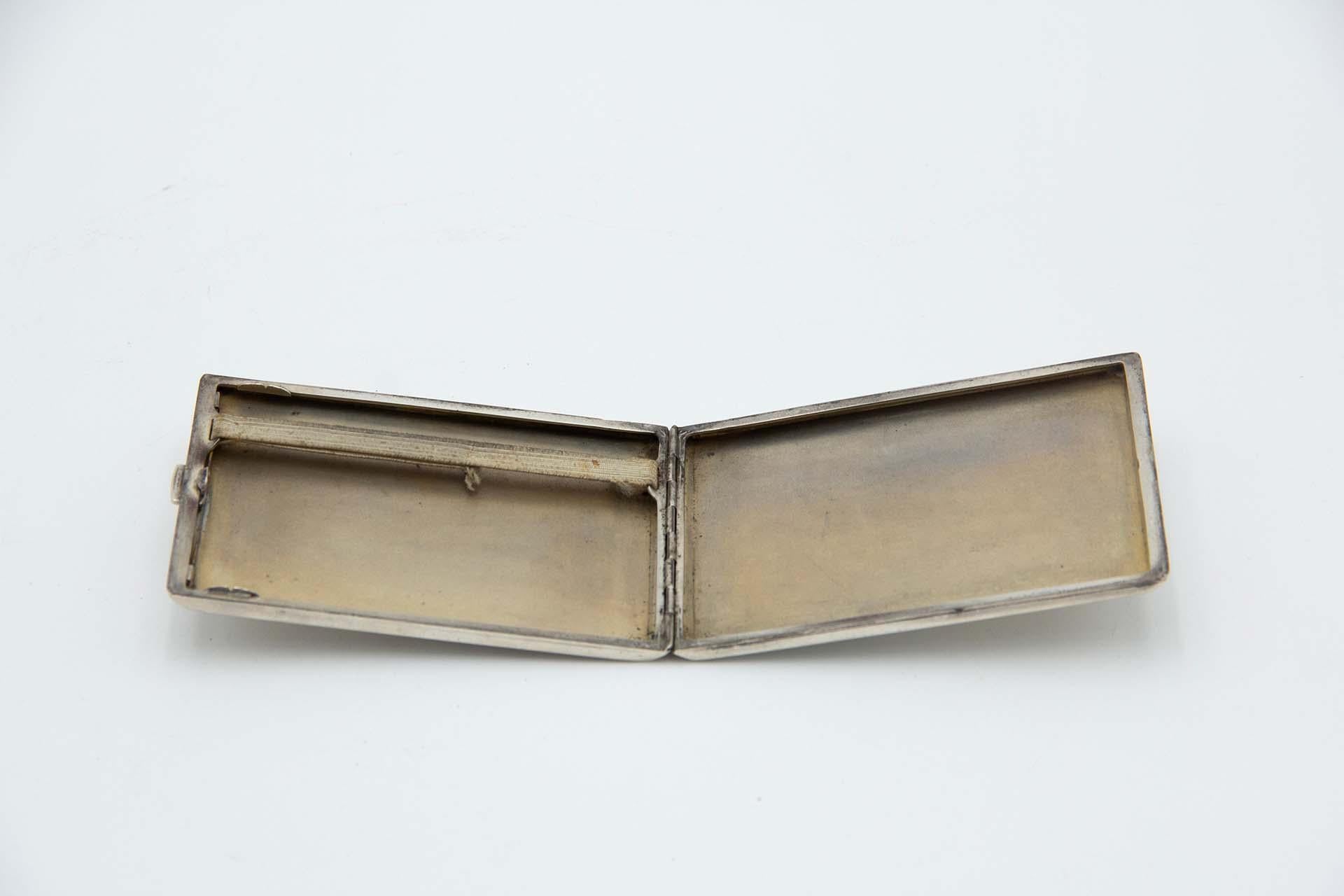 Description: Rectangular silver cigarette case with engraved asymmetrical patterns. Metal: Silver. Origin: Portuguese. Brand: javali II Title. Weight: 120.54 grams. Dimensions: 10.8cmx0.9cm. Content: 833/1000. Assay Mark: Yes, between 1887 and 1937.