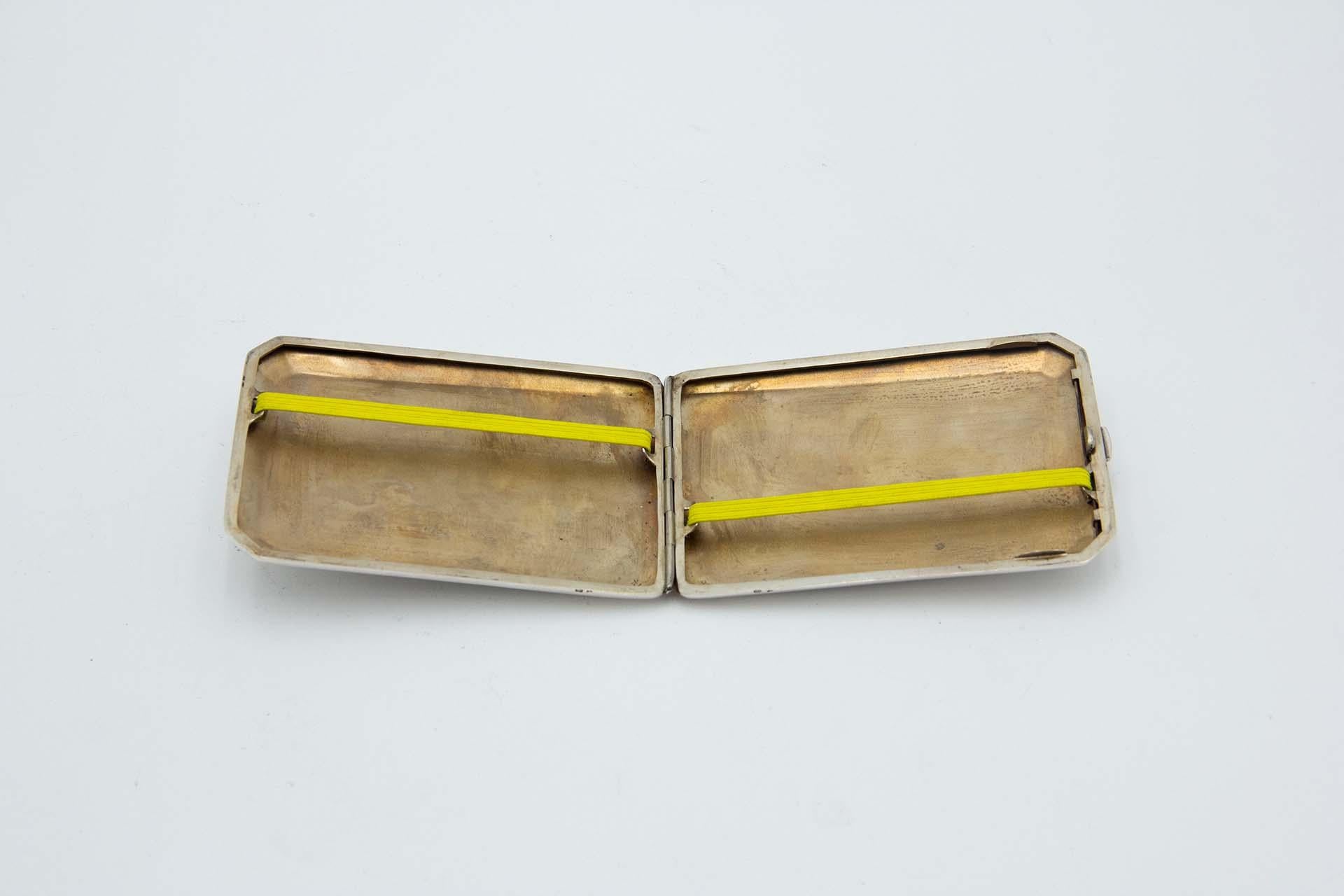 Descripción: Pitillera rectangular de plata con esquinas biseladas, bandas pulidas en plata mate y tarjeta con monograma. Metal: Silver. Origen: Portugués. Marca: javali II Título. Peso: 110,77 gramos. Dimensiones: 11,5cmx1,2cm. Contenido: 833/1000.