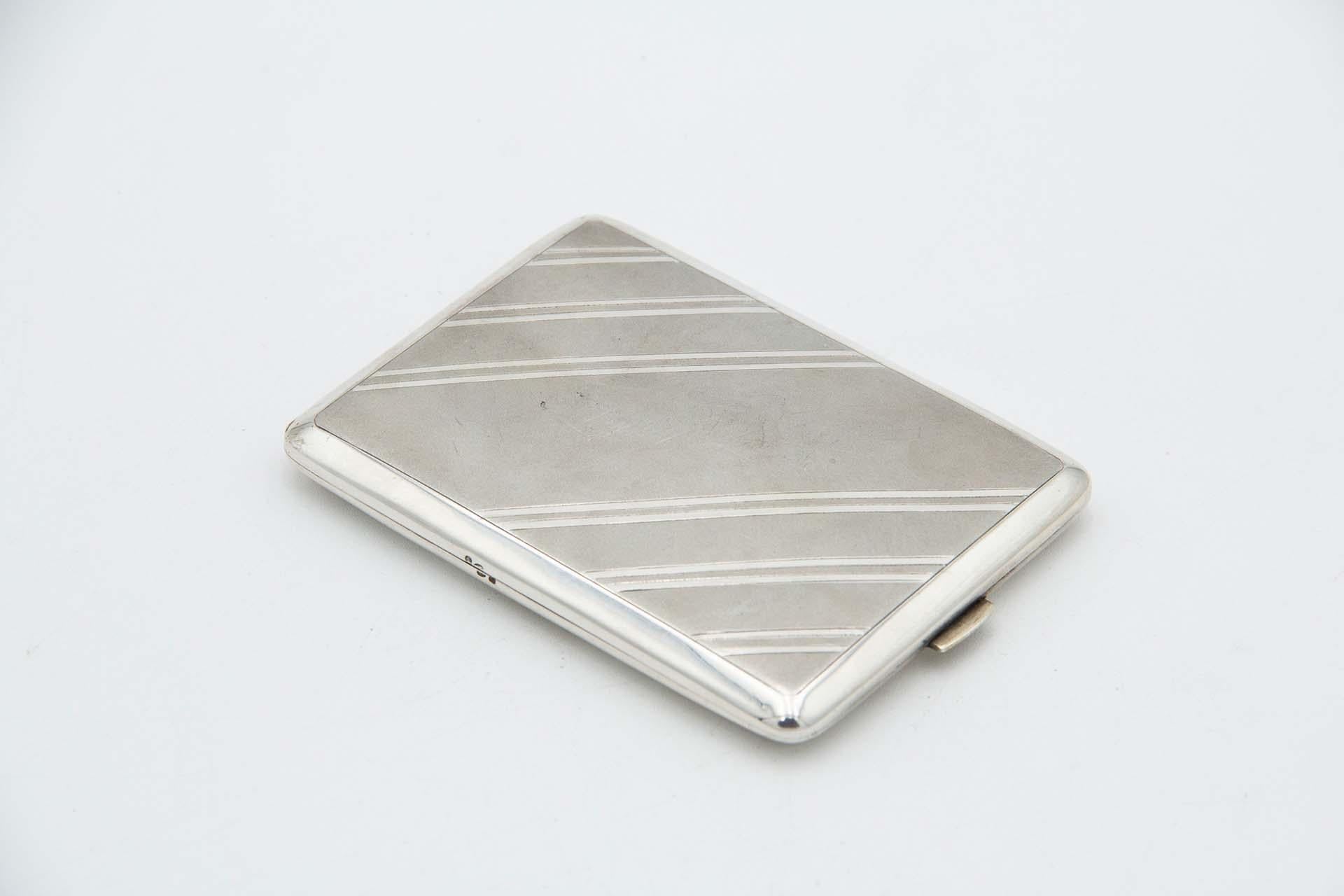 Description: Rectangular silver cigarette case with diagonal patterns on the hinged lid. Metal: Silver. Origin: Portuguese. Brand: javali II Title. Weight: 125.91 grams. Dimensions: 11.7cmx1.2cm. Content: 833/1000. Assay Mark: Yes, between 1887 and