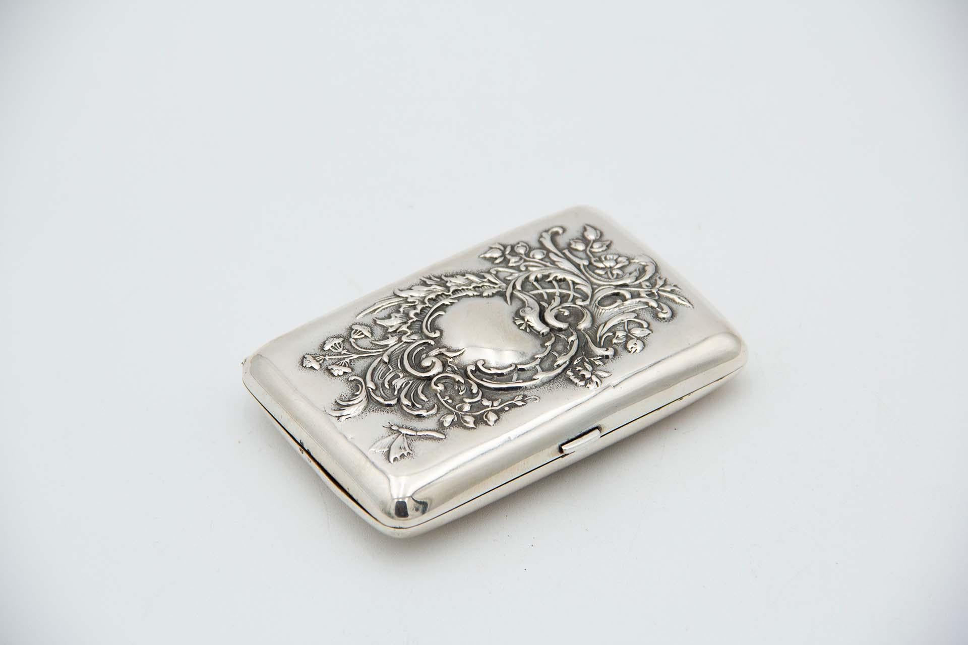 Description: Rectangular silver cigarette case with relief on the lid in Art Nouveau style. Metal: Silver. Origin: Portuguese. Brand: javali II Title. Weight: 76.49 grams. Dimensions: 9.2cmx1.8cm. Content: 833/1000. Assay Mark: Yes, between 1887 and