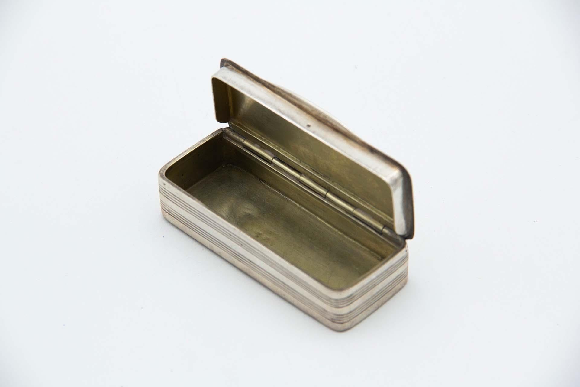 Beschreibung: Rechteckige silberne Schnupftabakdose mit Pflanzenmotiven, die eine Karte mit Monogramm umgeben, und Riffelung im Caninha-Stil. Metall: Silber. Herkunft: Europäisch. Marke: Unbekannt. Gewicht: 79,51 Gramm. Abmessungen: 8,5cmx2cm.