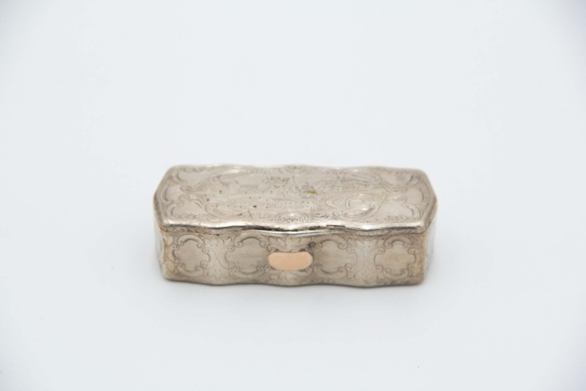 Beschreibung: Rechteckige silberne Schnupftabakdose mit gravierten Häusern in einem perfekten Rahmen, Pflanzenmotiven und Scharnierdeckel. Metall: Silber. Herkunft: Portugiesisch. Marke: Porto Coroa. Gewicht: 99,25 Gramm. Abmessungen: 9,7cmx2,6cm.