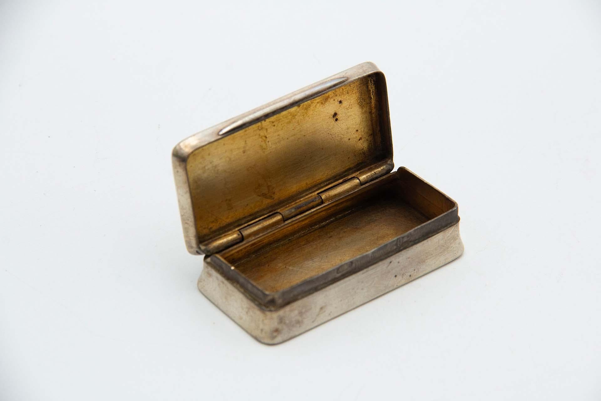 Beschreibung: Rechteckige silberne Schnupftabakdose mit glattem Deckel und geriffeltem Boden. Metall: Silber. Herkunft: Portugiesisch. Marke: Porto Coroa. Gewicht: 68,77 Gramm. Abmessungen: 7cmx1,7cm. Inhalt: 833/1000. Prüfzeichen: Ja, vom 15.