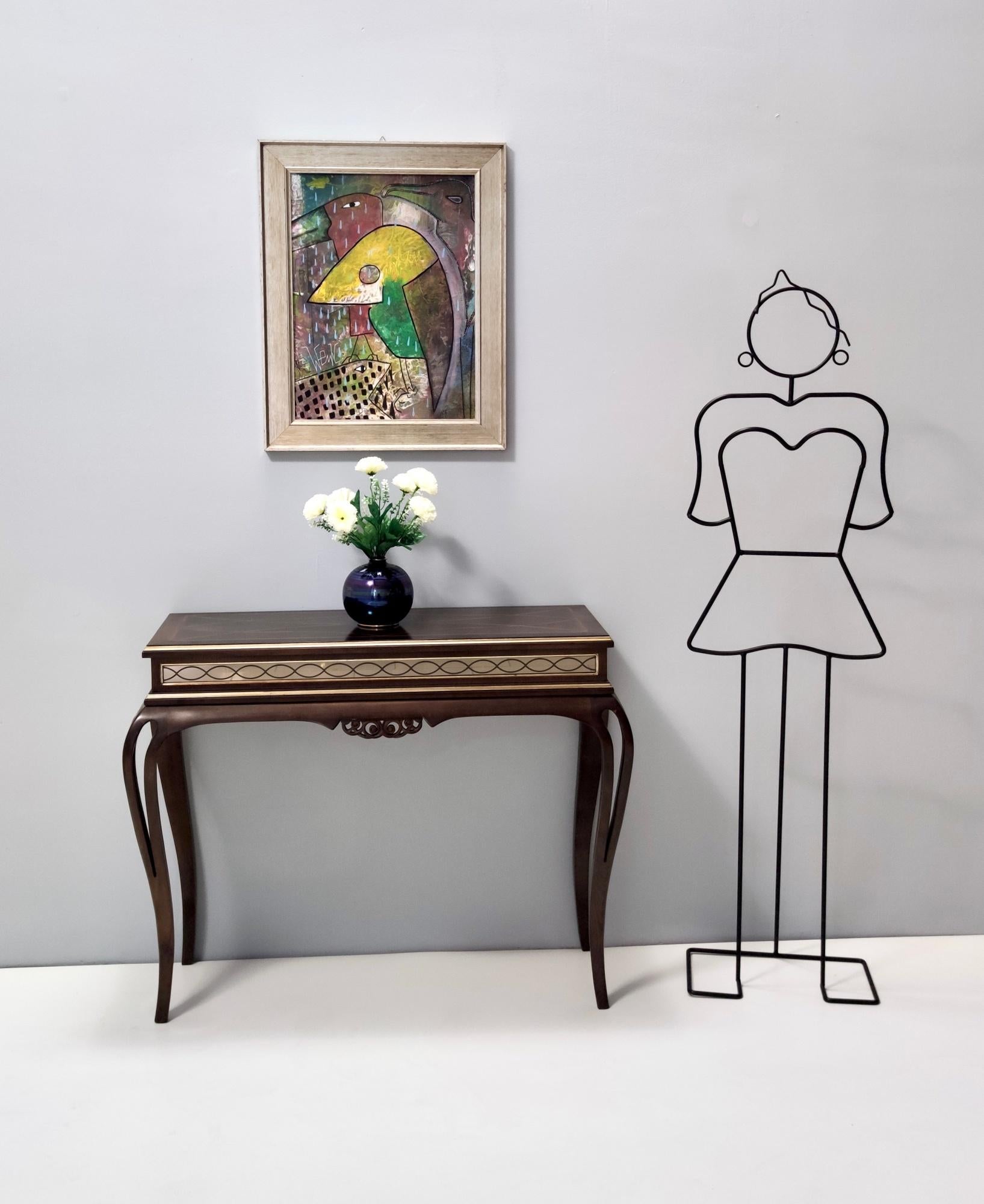 Fabriqué en Italie, années 1980.
Cette console présente un cadre en noyer massif avec un bandeau miroir gravé et des incrustations en hêtre.
Il peut présenter de légères traces d'utilisation puisqu'il est vintage, mais il peut être considéré comme