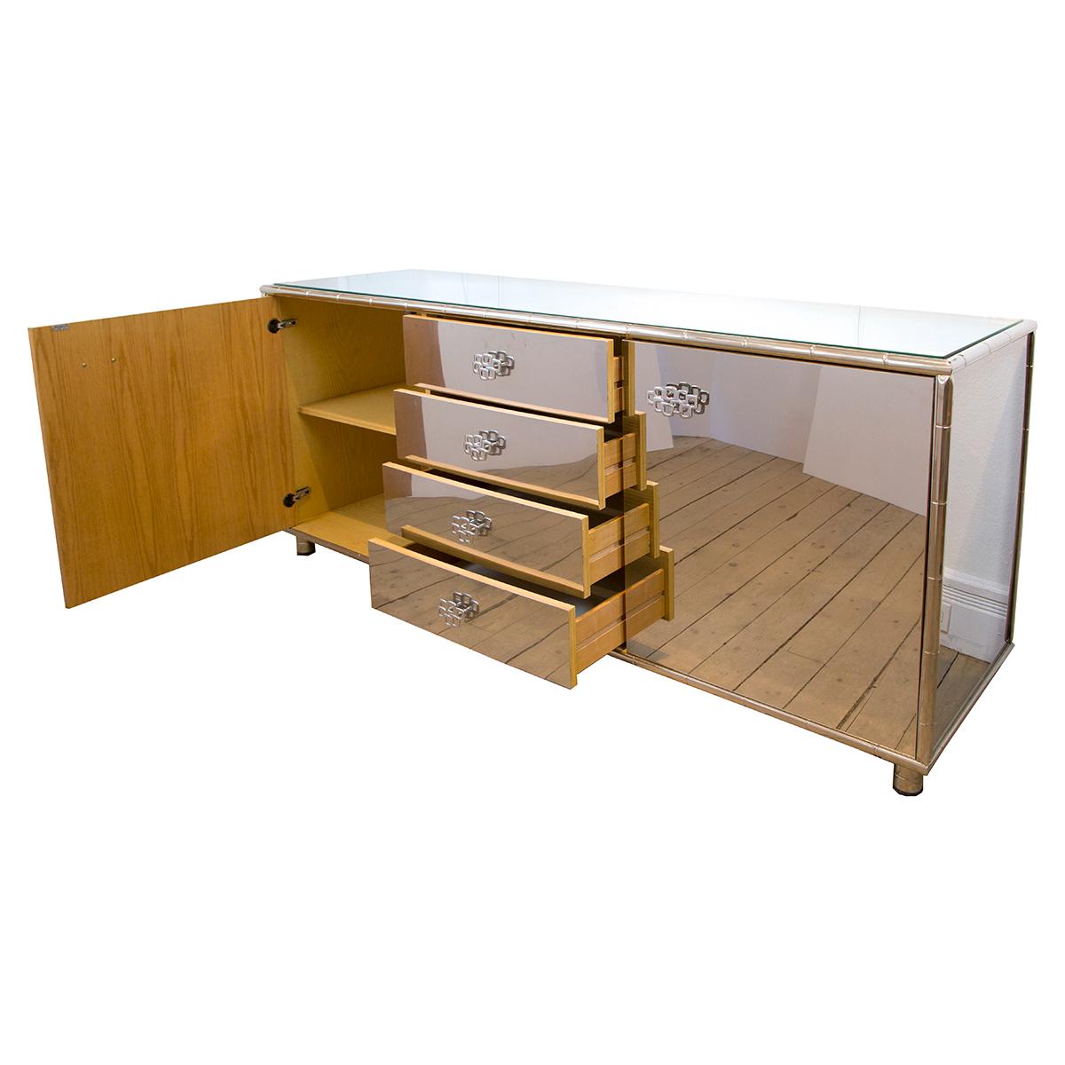 Rectangular stainless steel cabinet with faux bamboo trim, four drawers and interior shelves and with a glass top.