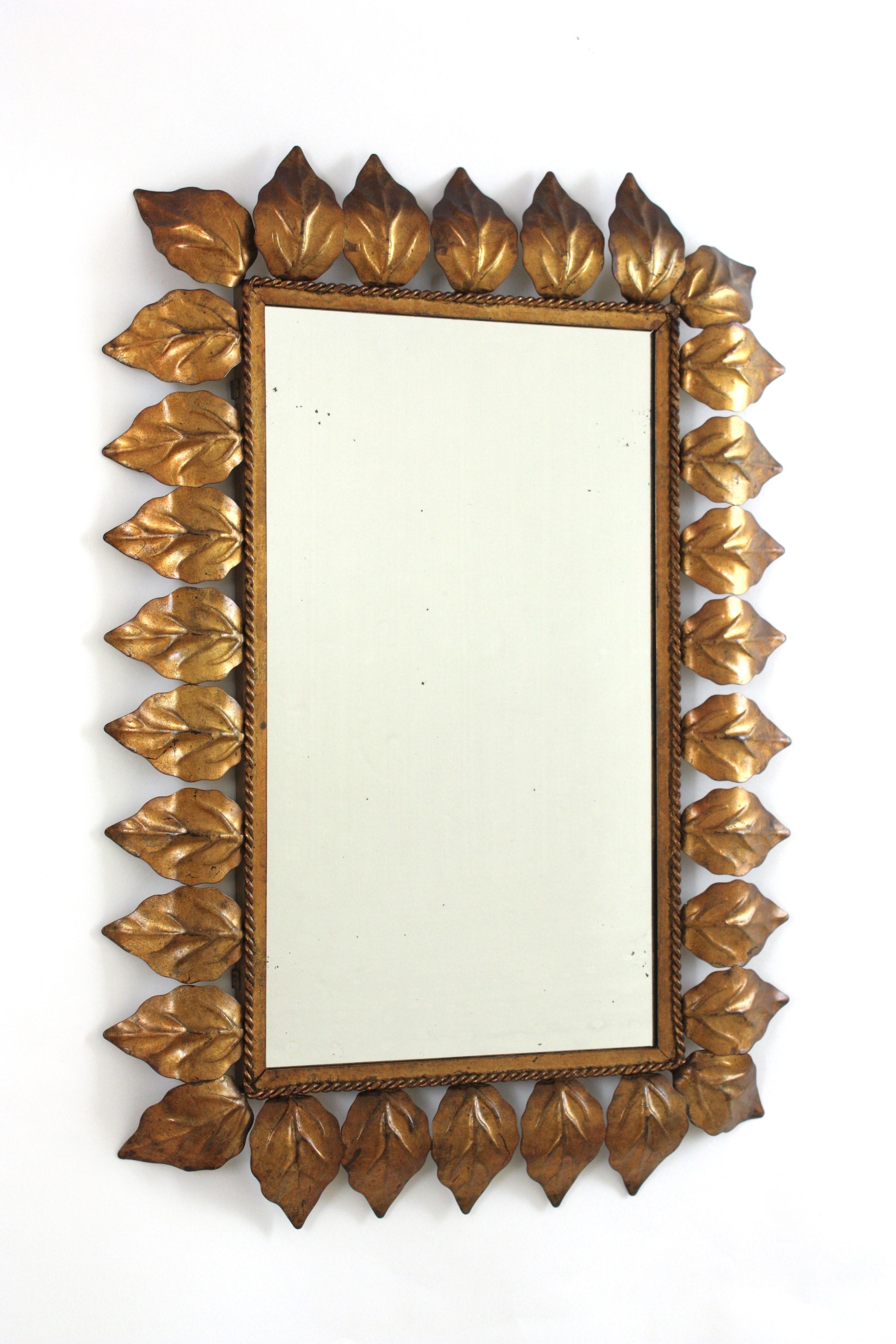 Gilt Iron Rectangular Sunburst Mirror Framed with Leaves, Spain, 1950s
An eye-catching sunburst mirror framed with elegant leaves and gold leaf gilded finish.
This mirror is in great vintage condition and has a terrific aged patina showing its
