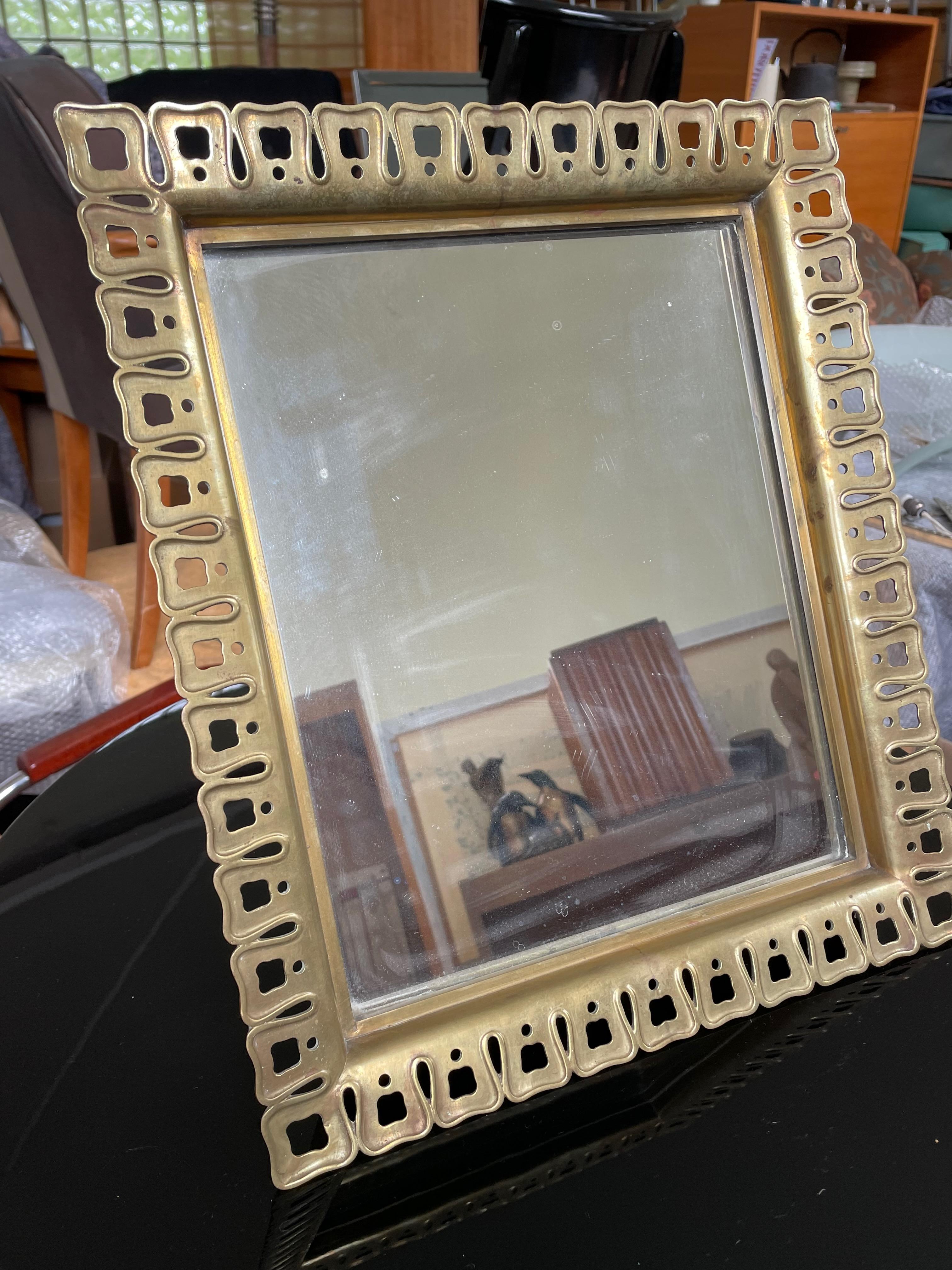 Rectangular table mirror. Italy.
Probably  from the forties/ fifties.
Mid century design.
Brutalist style.
Very heavy solid quality of the massive brass frame.
The mirror is reminiscent of works by Luciano Frigerio.